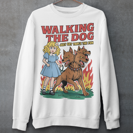 White Sweatshirt featuring a colorful cartoon design of a young girl in a blue dress casually walking a three-headed Cerberus dog on a leash. The fierce hellhound snarls with sharp teeth while flames rise behind it, creating a striking contrast between cute and chaotic. Bold red text reads “Walking the Dog” with smaller text below saying “Just Got Triple the Fun,” adding humor to the fantasy-inspired scene.