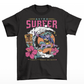 Black t-shirt of a female alien surfing on Mars with tiki and flowers and text above ASTRO SURFER. And text below ALWAYS SUMMER ON MARS.