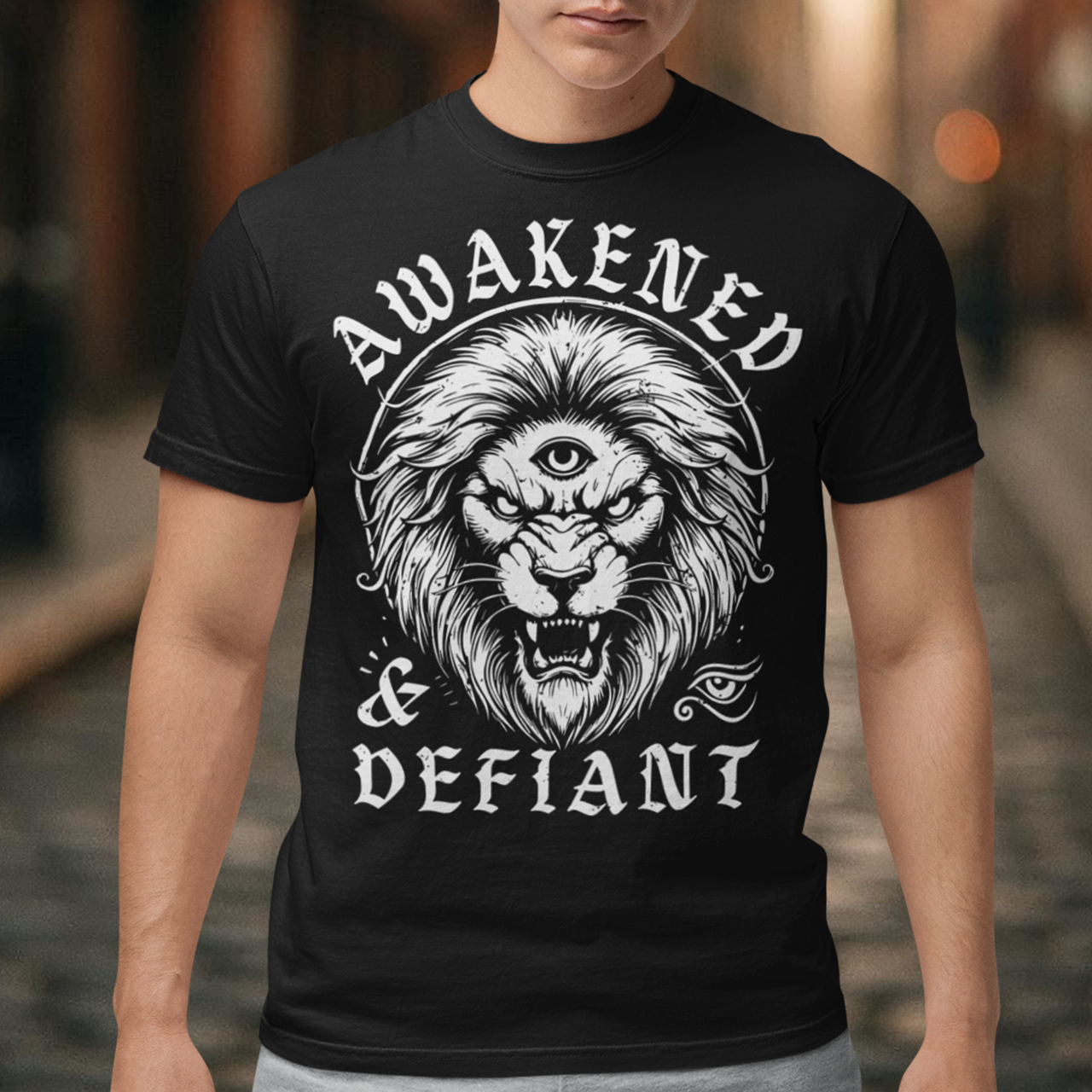 Unleash your inner power with this bold and striking t-shirt featuring a fierce lion with a mystical third eye, symbolizing heightened awareness and untamed strength. The detailed artwork showcases the lion’s intense gaze, radiating wisdom and defiance, while the text "AWAKENED and DEFIANT" amplifies the message of resilience and enlightenment. This tee is perfect for those who stand fearless, awakened, and unapologetically themselves. Wear it and embrace the spirit of the untamed.
