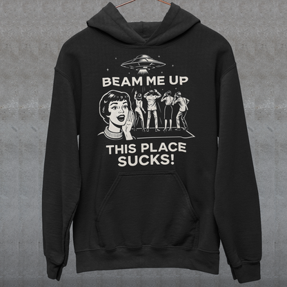 This snark-powered retro UFO hoodie brings the perfect escape fantasy to life. A vintage-style flying saucer hovers above a crowd while a wide-eyed woman rallies for interstellar rescue, paired with the bold line “Beam Me Up, This Place Sucks!” The design has a classic pulp-sci-fi look that feels like it tumbled out of an old comic rack. Ideal for anyone who survives their days with eye rolls, cosmic daydreams, and a desire to be anywhere else in the galaxy.
