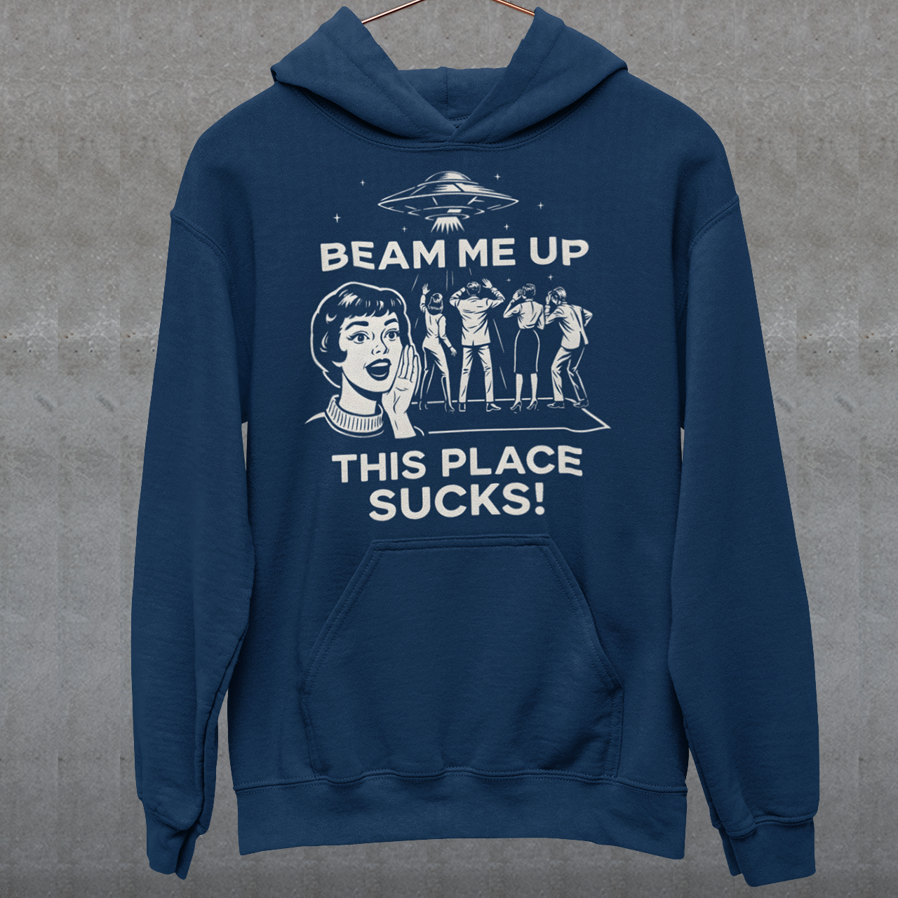 This snark-powered retro UFO hoodie brings the perfect escape fantasy to life. A vintage-style flying saucer hovers above a crowd while a wide-eyed woman rallies for interstellar rescue, paired with the bold line “Beam Me Up, This Place Sucks!” The design has a classic pulp-sci-fi look that feels like it tumbled out of an old comic rack. Ideal for anyone who survives their days with eye rolls, cosmic daydreams, and a desire to be anywhere else in the galaxy.