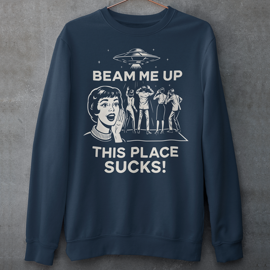 This snark-powered retro UFO sweatshirt brings the perfect escape fantasy to life. A vintage-style flying saucer hovers above a crowd while a wide-eyed woman rallies for interstellar rescue, paired with the bold line “Beam Me Up, This Place Sucks!” The design has a classic pulp-sci-fi look that feels like it tumbled out of an old comic rack. Ideal for anyone who survives their days with eye rolls, cosmic daydreams, and a desire to be anywhere else in the galaxy.