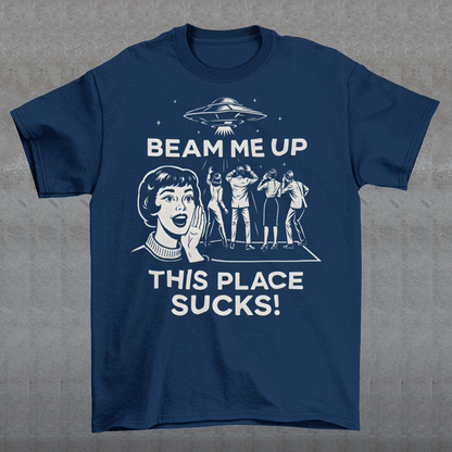 This snark-powered retro UFO t-shirt brings the perfect escape fantasy to life. A vintage-style flying saucer hovers above a crowd while a wide-eyed woman rallies for interstellar rescue, paired with the bold line “Beam Me Up, This Place Sucks!” The design has a classic pulp-sci-fi look that feels like it tumbled out of an old comic rack. Ideal for anyone who survives their days with eye rolls, cosmic daydreams, and a desire to be anywhere else in the galaxy.