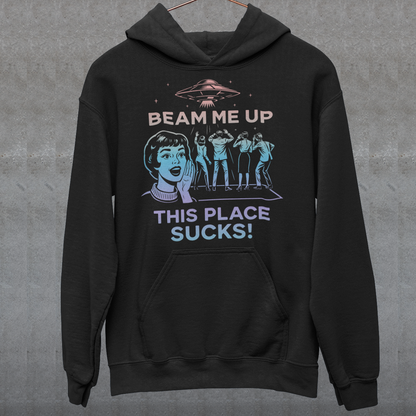 This snark-powered retro UFO hoodie brings the perfect escape fantasy to life. A vintage-style flying saucer hovers above a crowd while a wide-eyed woman rallies for interstellar rescue, paired with the bold line “Beam Me Up, This Place Sucks!” The design has a classic pulp-sci-fi look that feels like it tumbled out of an old comic rack. Ideal for anyone who survives their days with eye rolls, cosmic daydreams, and a desire to be anywhere else in the galaxy.