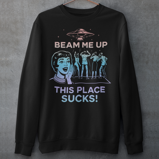 This snark-powered retro UFO sweatshirt brings the perfect escape fantasy to life. A vintage-style flying saucer hovers above a crowd while a wide-eyed woman rallies for interstellar rescue, paired with the bold line “Beam Me Up, This Place Sucks!” The design has a classic pulp-sci-fi look that feels like it tumbled out of an old comic rack. Ideal for anyone who survives their days with eye rolls, cosmic daydreams, and a desire to be anywhere else in the galaxy.