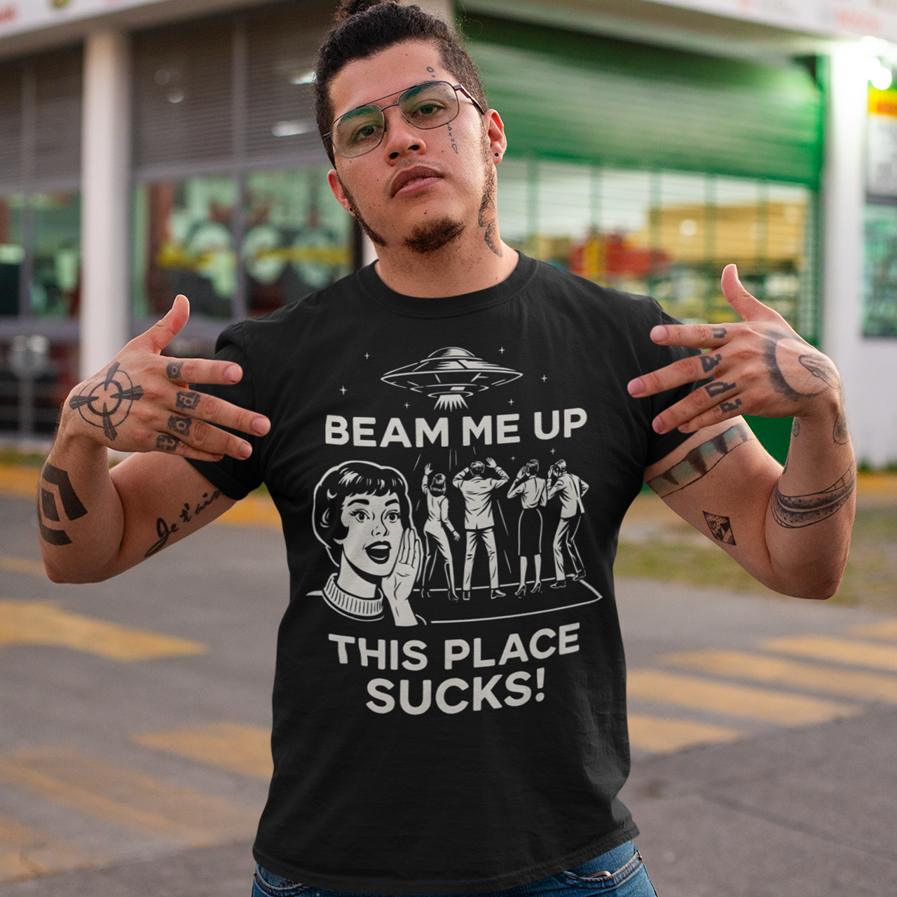 This snark-powered retro UFO t-shirt brings the perfect escape fantasy to life. A vintage-style flying saucer hovers above a crowd while a wide-eyed woman rallies for interstellar rescue, paired with the bold line “Beam Me Up, This Place Sucks!” The design has a classic pulp-sci-fi look that feels like it tumbled out of an old comic rack. Ideal for anyone who survives their days with eye rolls, cosmic daydreams, and a desire to be anywhere else in the galaxy.