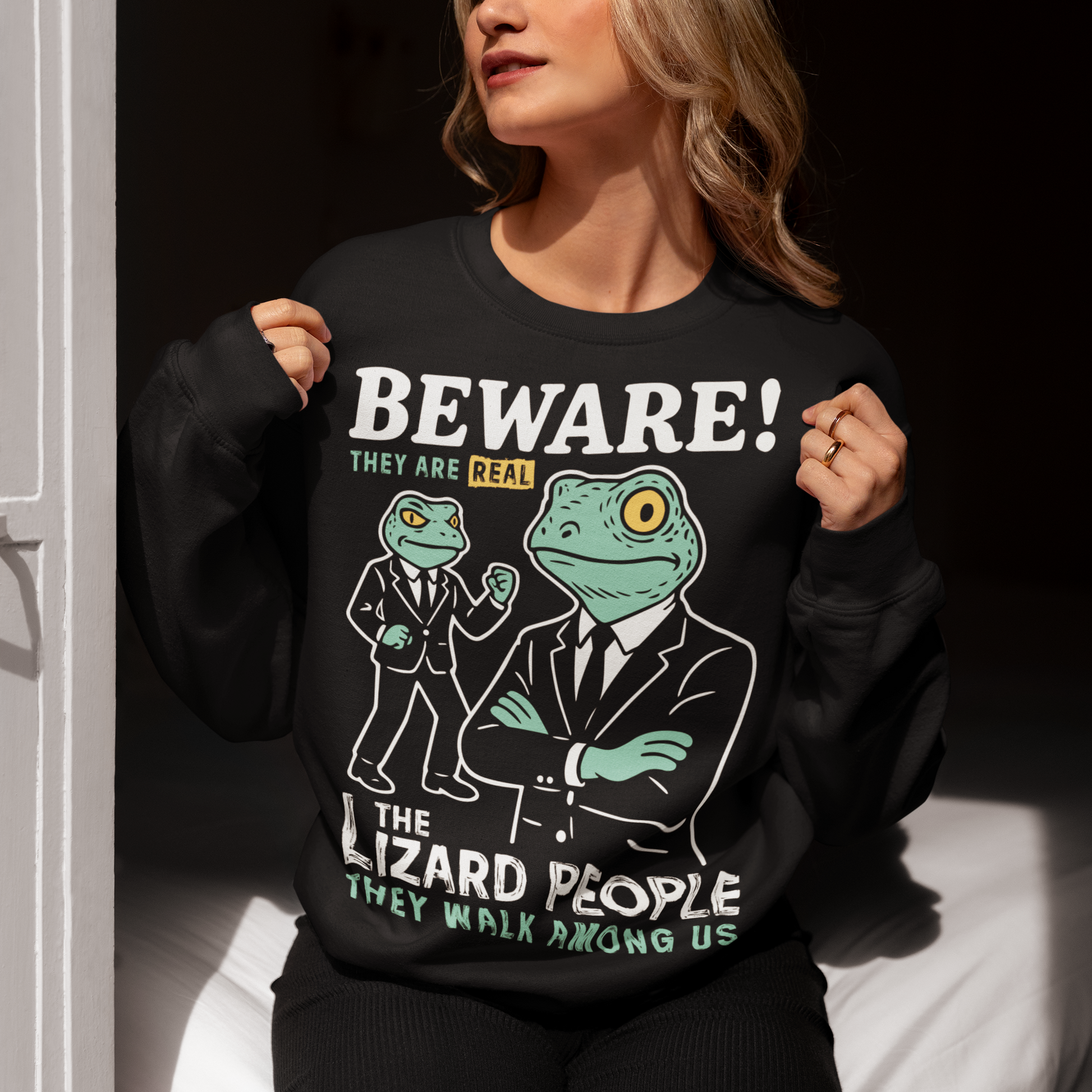 This “Beware! Lizard People” sweatshirt turns a classic conspiracy wink into wearable humor. The suited-up reptilian characters strike a bold, comic-book stance that adds a playful sense of intrigue to your outfit. Crisp line art and a vintage poster feel make it a standout for sci-fi lovers, meme collectors, and anyone who enjoys a touch of tongue-in-cheek absurdity. It’s the perfect shirt for sparking conversations and raising eyebrows in all the right ways.
