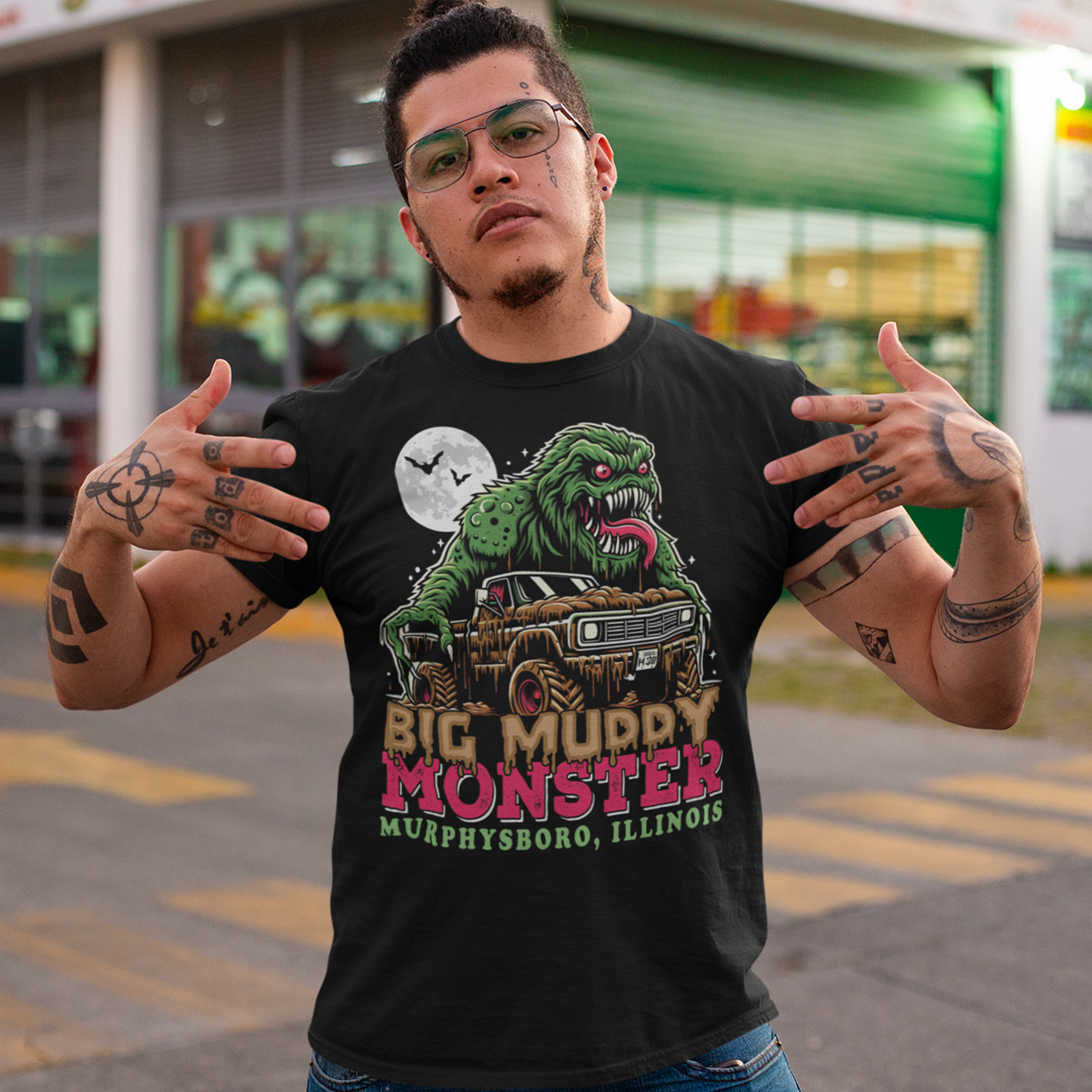 Black t-shirt of the Murphysboro Mud Monster attacking a truck with text "BIG MUDDY MONSTER".