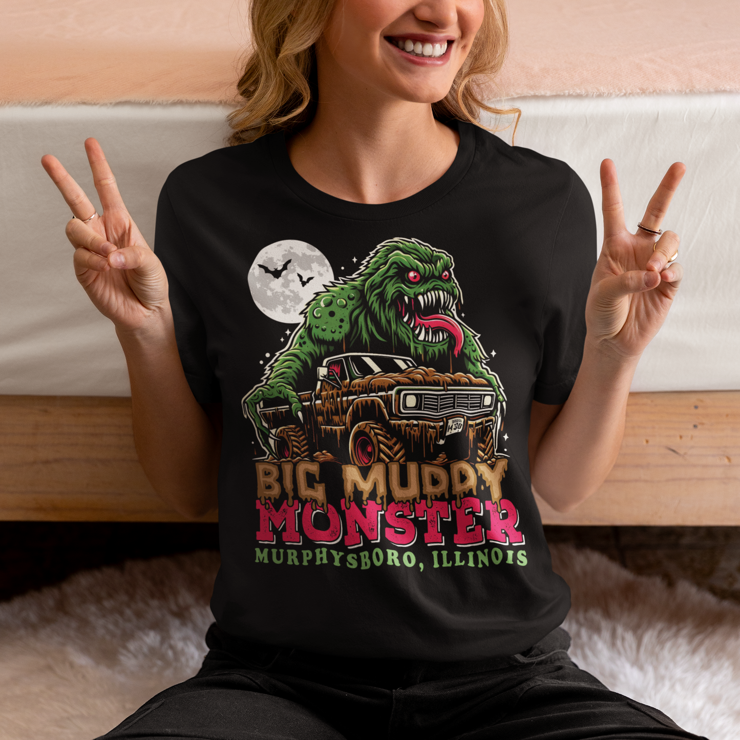 Black t-shirt of the Murphysboro Mud Monster attacking a truck with text "BIG MUDDY MONSTER".