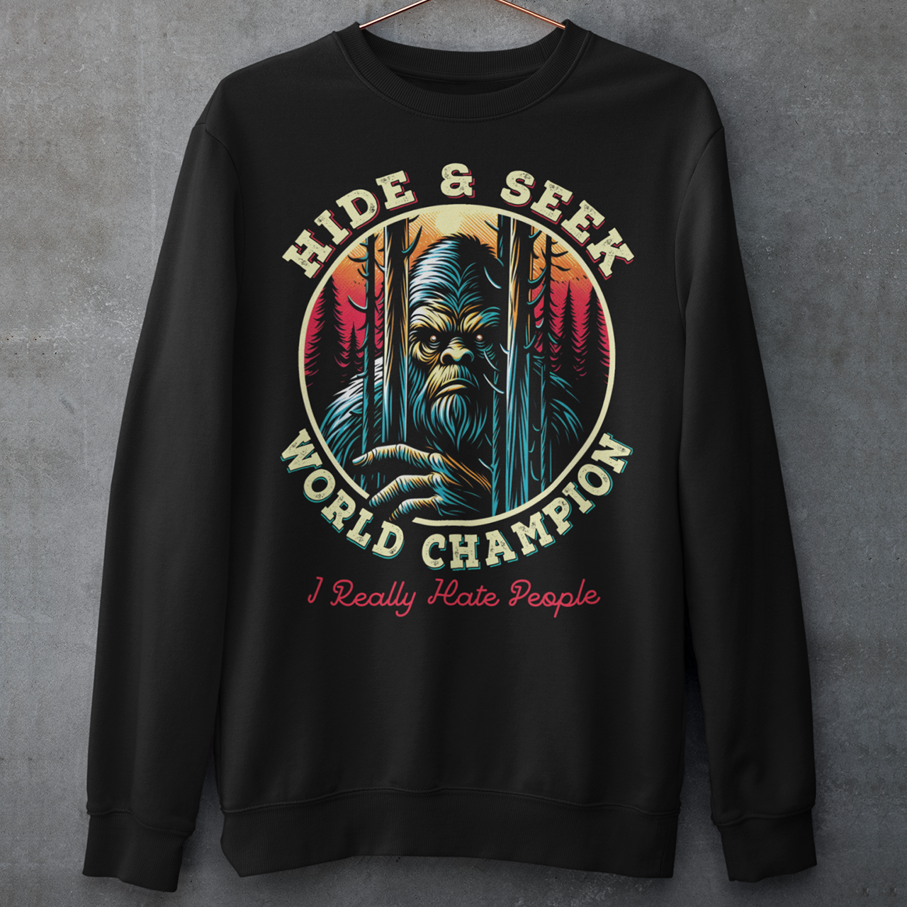 Black sweatshirt of Bigfoot peeking through trees with text HIDE & SEEK WORLD CHAMPION.