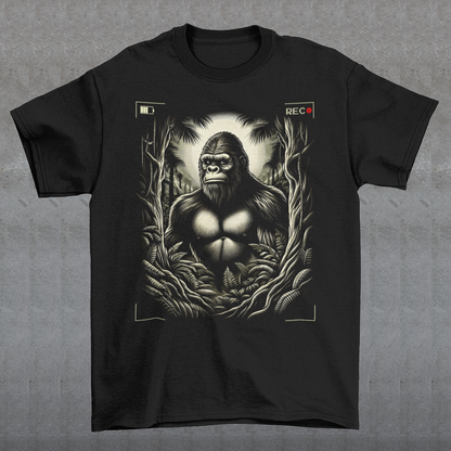 This t-shirt features a captivating and mysterious scene: Bigfoot, the legendary creature of folklore, is depicted peeking through dense, shadowy trees. The design captures the thrill of a rare sighting with intricate details, from the leaves rustling in the breeze to Bigfoot's curious expression.