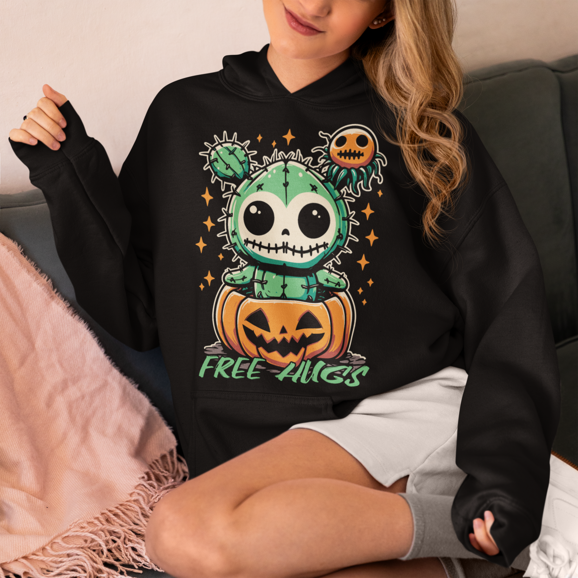 Black Halloween hoodie of a cactus teddy in a pumpkin with text underneath "FREE HUGS."