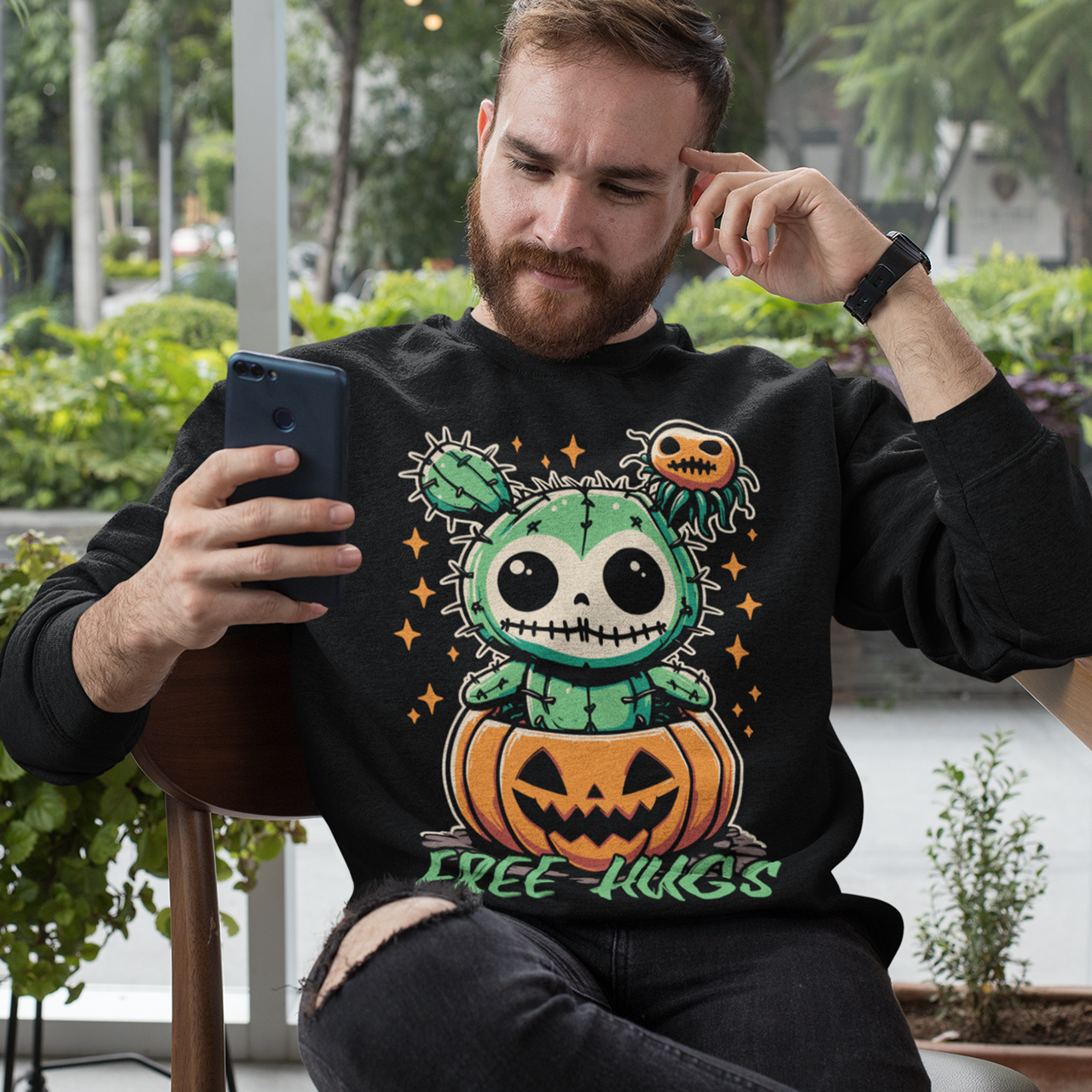 Black Halloween sweatshirt of a cactus teddy in a pumpkin with text underneath "FREE HUGS."