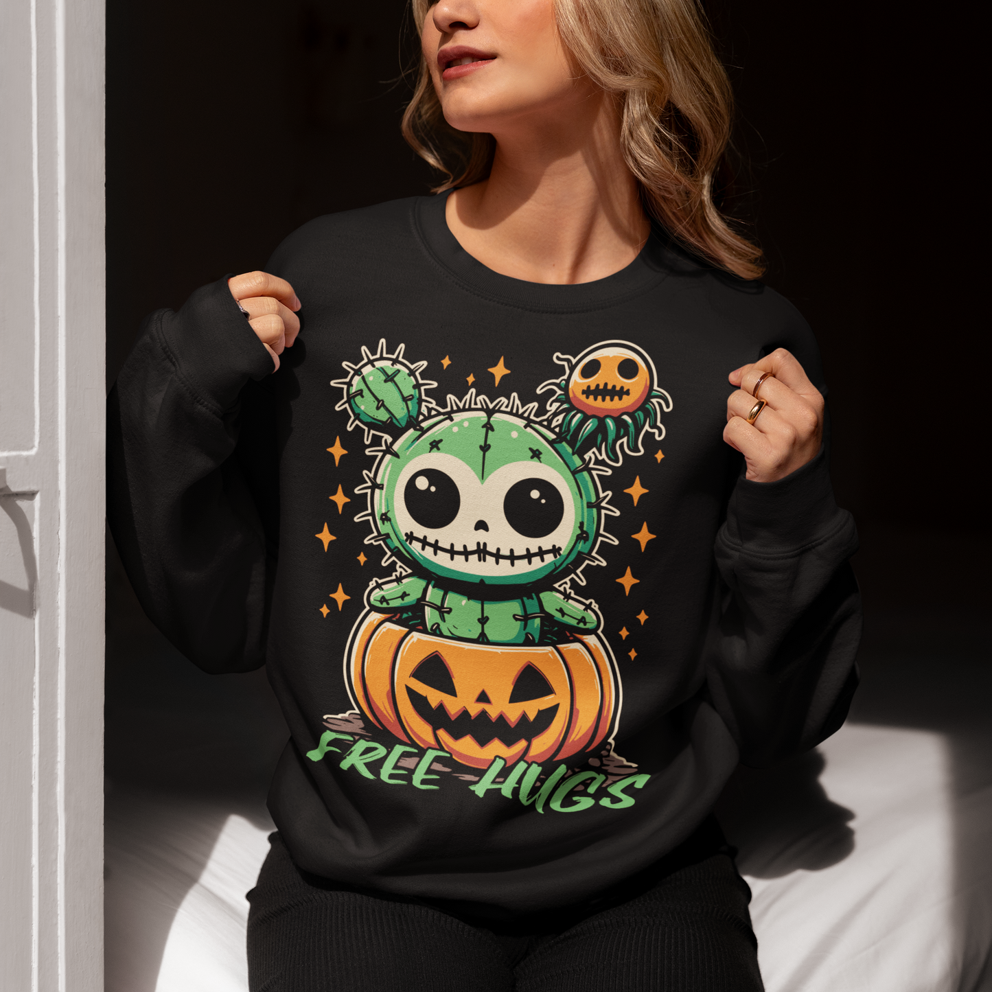 Black Halloween sweatshirt of a cactus teddy in a pumpkin with text underneath "FREE HUGS."