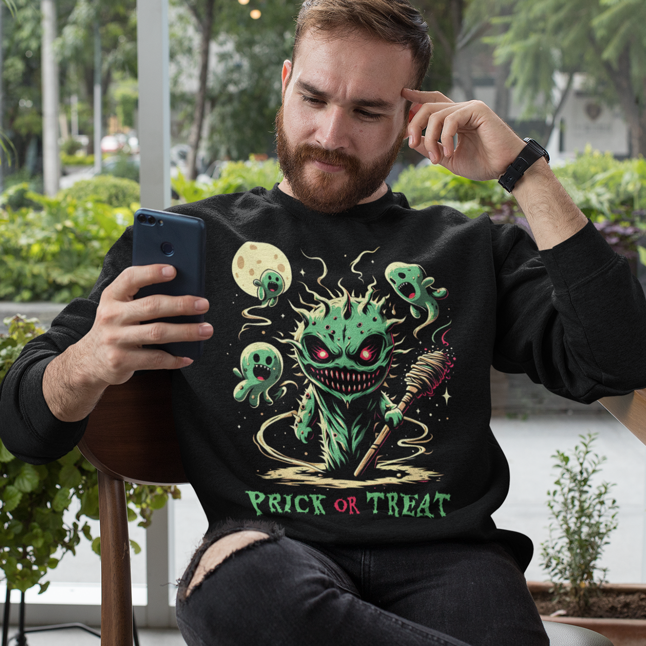 Black Halloween sweatshirt of a scary cactus with cactus ghosts with text underneath "PRICK OR TREAT".