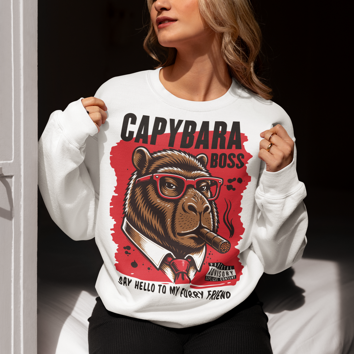 White sweatshirt featuring a bold vintage-style capybara graphic wearing red sunglasses, a suit and tie, and smoking a cigar. The design includes “CAPYBARA BOSS” text, a red background, and the phrase “SAY HELLO TO MY FURRY FRIEND,” creating a funny gangster-inspired animal design for capybara lovers and meme fans.