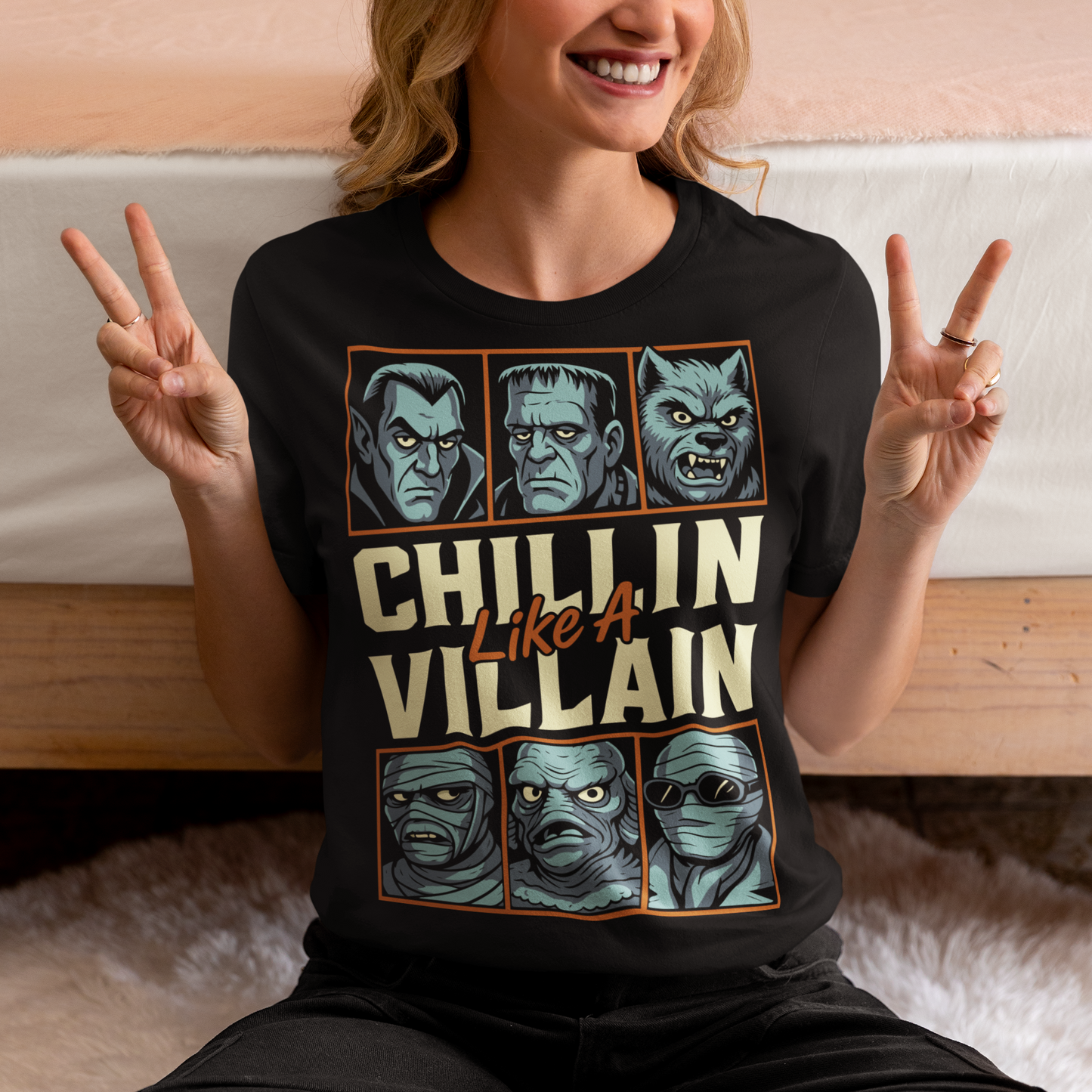 Black t-shirt featuring the phrase "Chillin Like A Villain" with six classic horror monster portraits, including a vampire, Frankenstein's monster, werewolf, mummy, swamp creature, and the Invisible Man. The retro-inspired graphic uses distressed vintage styling with bold cream and orange lettering, making it a fun horror-themed shirt for Halloween, monster movie fans, goth fashion lovers, and classic horror enthusiasts.