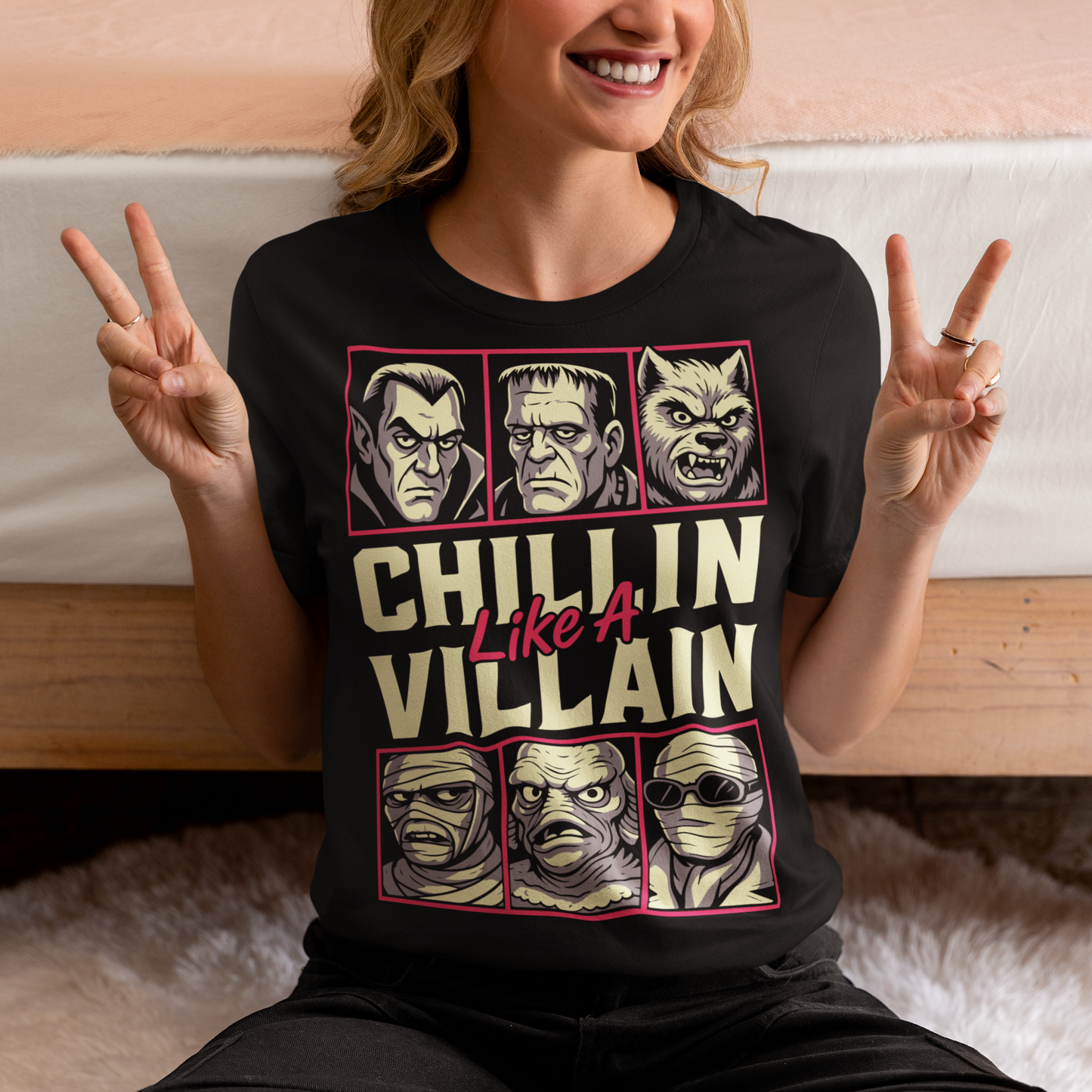 Black t-shirt featuring the phrase "Chillin Like A Villain" with six classic horror monster portraits, including a vampire, Frankenstein's monster, werewolf, mummy, swamp creature, and the Invisible Man. The retro-inspired graphic uses distressed vintage styling with bold cream and pink lettering, making it a fun horror-themed shirt for Halloween, monster movie fans, goth fashion lovers, and classic horror enthusiasts.