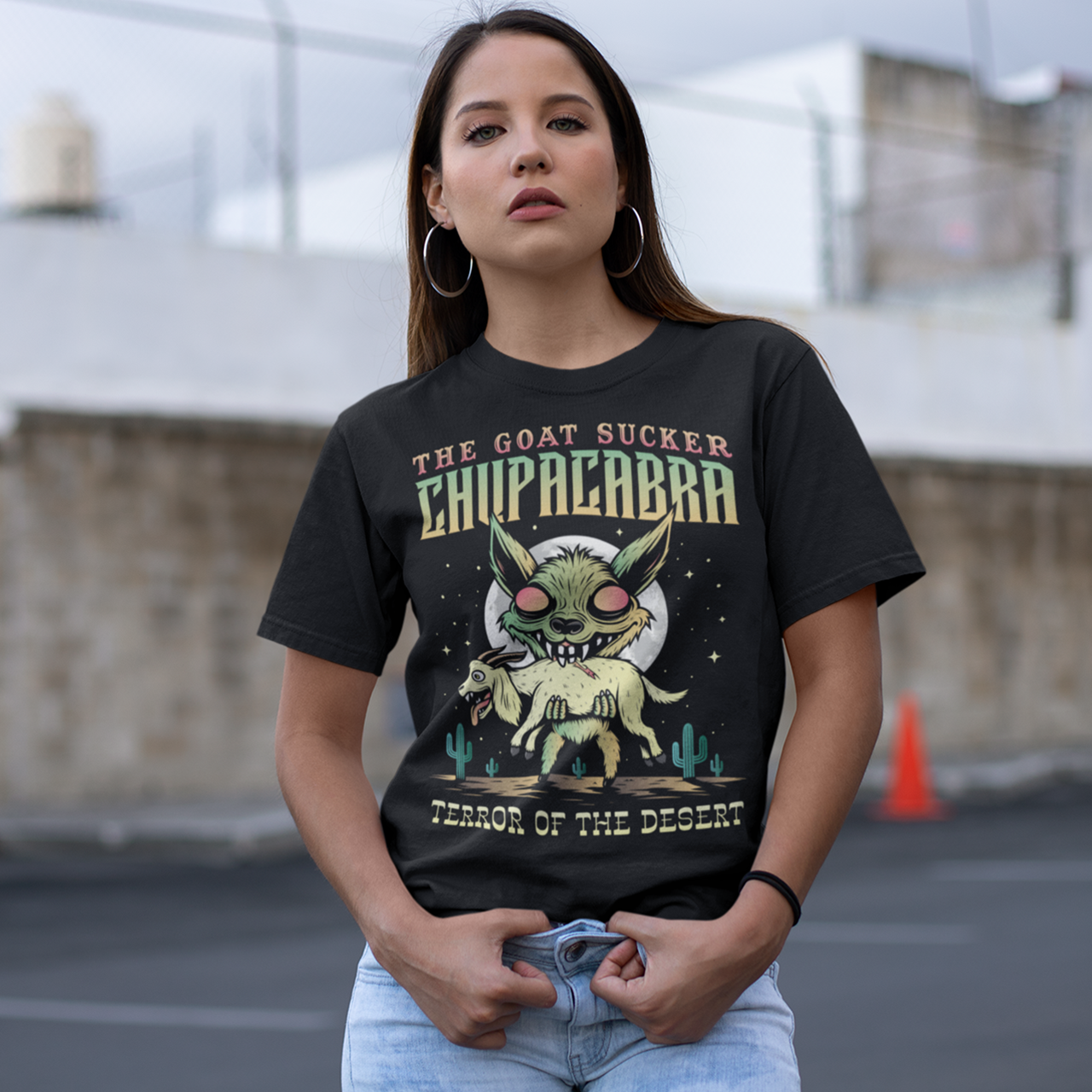 Black t-shirt of a chupacabra sucking on a goat in the desert with text above THE GOAT SUCKER CHUPACABRA ang text below TERROR OF THE DESERT.