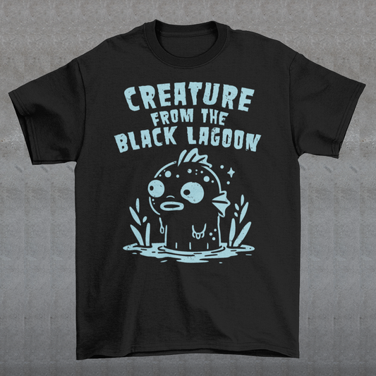 Make a splash with this fun twist on a horror classic! This t-shirt features a playful cartoon version of the Gill-man, the iconic monster from Creature from the Black Lagoon. Above the illustration, bold retro lettering reads “CREATURE FROM THE BLACK LAGOON”, giving the design an authentic vintage movie-poster vibe. Perfect for monster movie fans, collectors of cult classics, or anyone who loves quirky, eye-catching style.