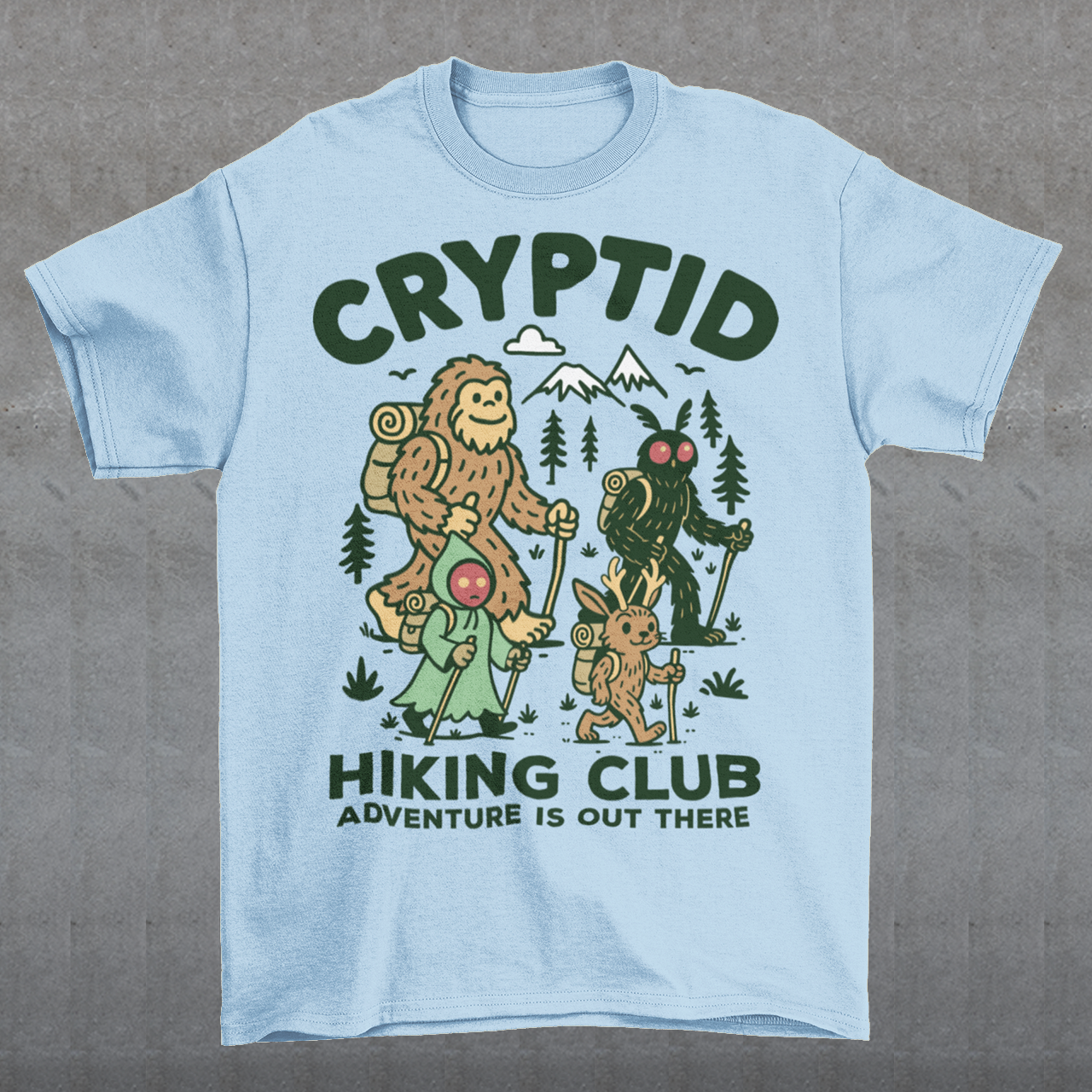 Light blue t-shirt featuring a playful “Cryptid Hiking Club” design with Bigfoot, Mothman, flatwoods monster, and a jackalope hiking together through a forest trail. The artwork includes mountains, pine trees, backpacks, and trekking poles with the slogan “Adventure Is Out There.” A fun outdoor-themed graphic perfect for cryptid fans, hikers, campers, paranormal enthusiasts, and lovers of folklore-inspired apparel.