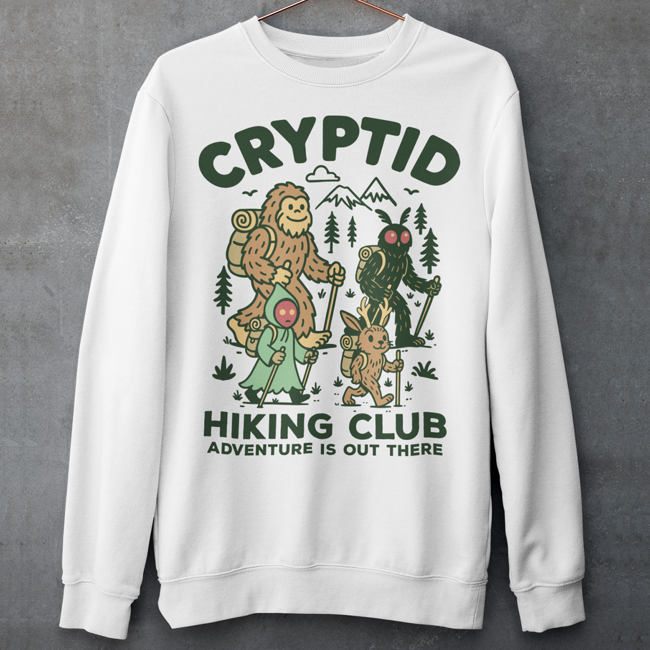 White sweatshirt featuring a playful “Cryptid Hiking Club” design with Bigfoot, Mothman, flatwoods monster, and a jackalope hiking together through a forest trail. The artwork includes mountains, pine trees, backpacks, and trekking poles with the slogan “Adventure Is Out There.” A fun outdoor-themed graphic perfect for cryptid fans, hikers, campers, paranormal enthusiasts, and lovers of folklore-inspired apparel.
