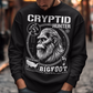 Illustration of a cryptozoology-themed sweatshirt featuring a stylized image of Bigfoot's head, shown with shaggy fur, deep-set eyes, and a mysterious expression. The artwork has a bold, rugged design in earthy tones, emphasizing the mythical nature of the creature. Above the image, the words "CRYPTID HUNTER" are prominently displayed in large, distressed lettering, suggesting adventure and mystery. The design appeals to fans of folklore, legends, and unexplained phenomena.