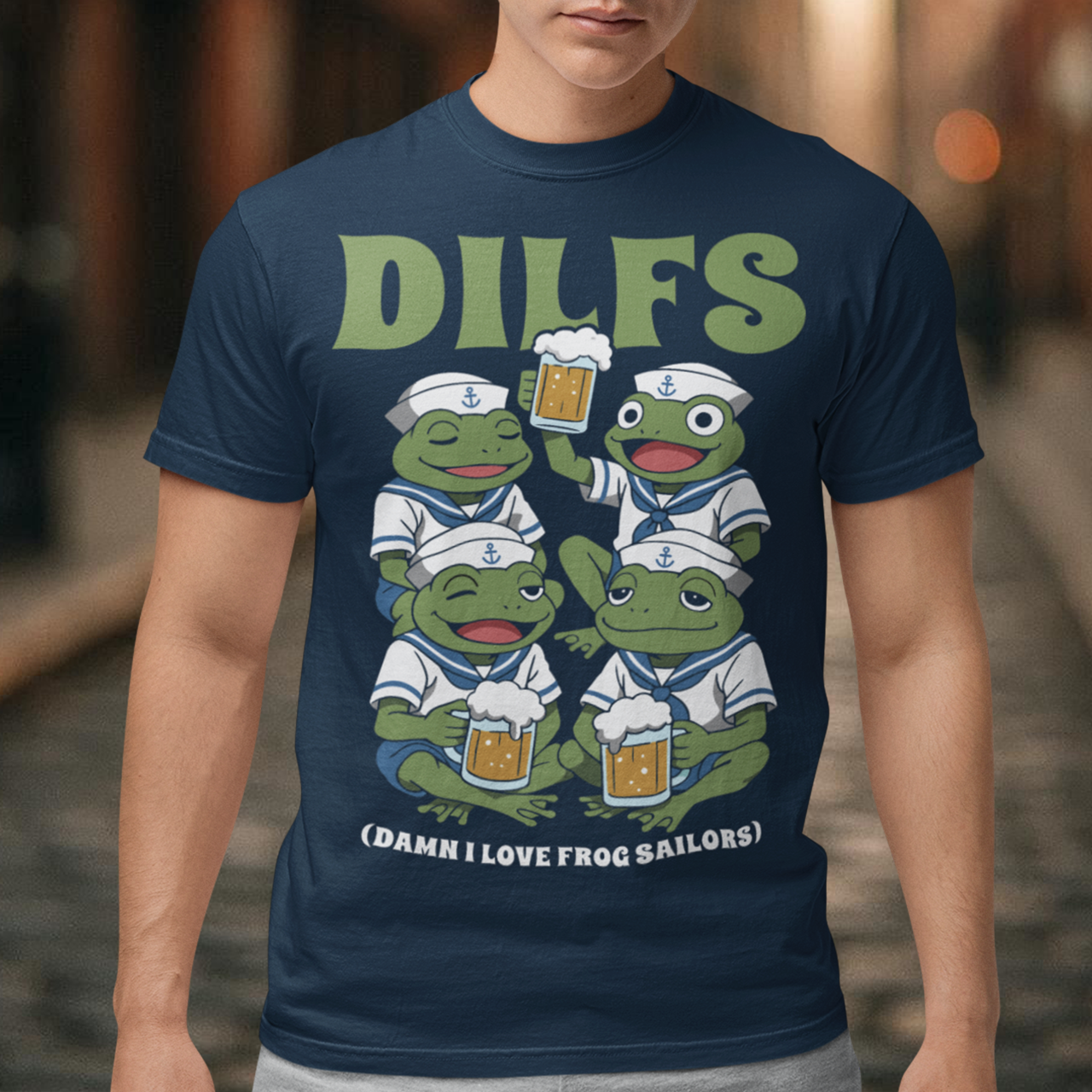 Navy t-shirt featuring a humorous cartoon design of four green frogs dressed as sailors, each wearing a white navy uniform and hat with anchor symbols. The frogs are smiling and holding mugs of beer, with one raising a drink in a toast. Large green text at the top reads “DILFS,” and smaller text below says “Damn I Love Frog Sailors,” creating a playful and funny nautical-themed graphic.