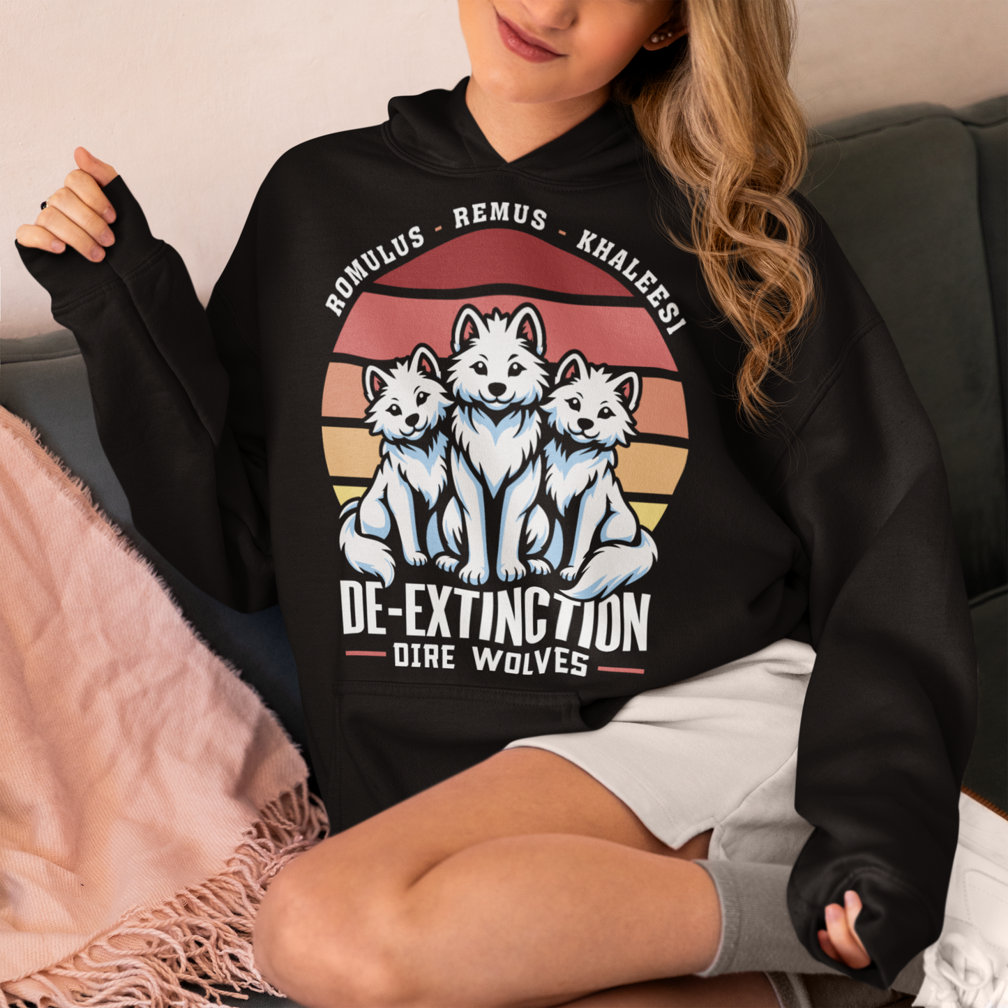 Black hoodie of three Dire Wolves sitting in front of a retro sun with text below DE-EXTINCTION.