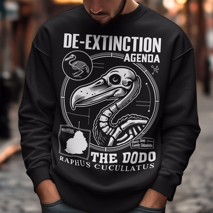A graphic sweatshirt featuring a stylized illustration of a dodo bird, standing upright with a proud, almost defiant expression. The dodo is depicted in vibrant colors, blending realism with a slightly cartoonish flair. Above the bird, bold, capitalized text reads "DE-EXTINCTION AGENDA" in a futuristic font, suggesting a science fiction or activist tone. The design evokes themes of genetic engineering, conservation, and the revival of extinct species. The shirt is a statement piece with humor.