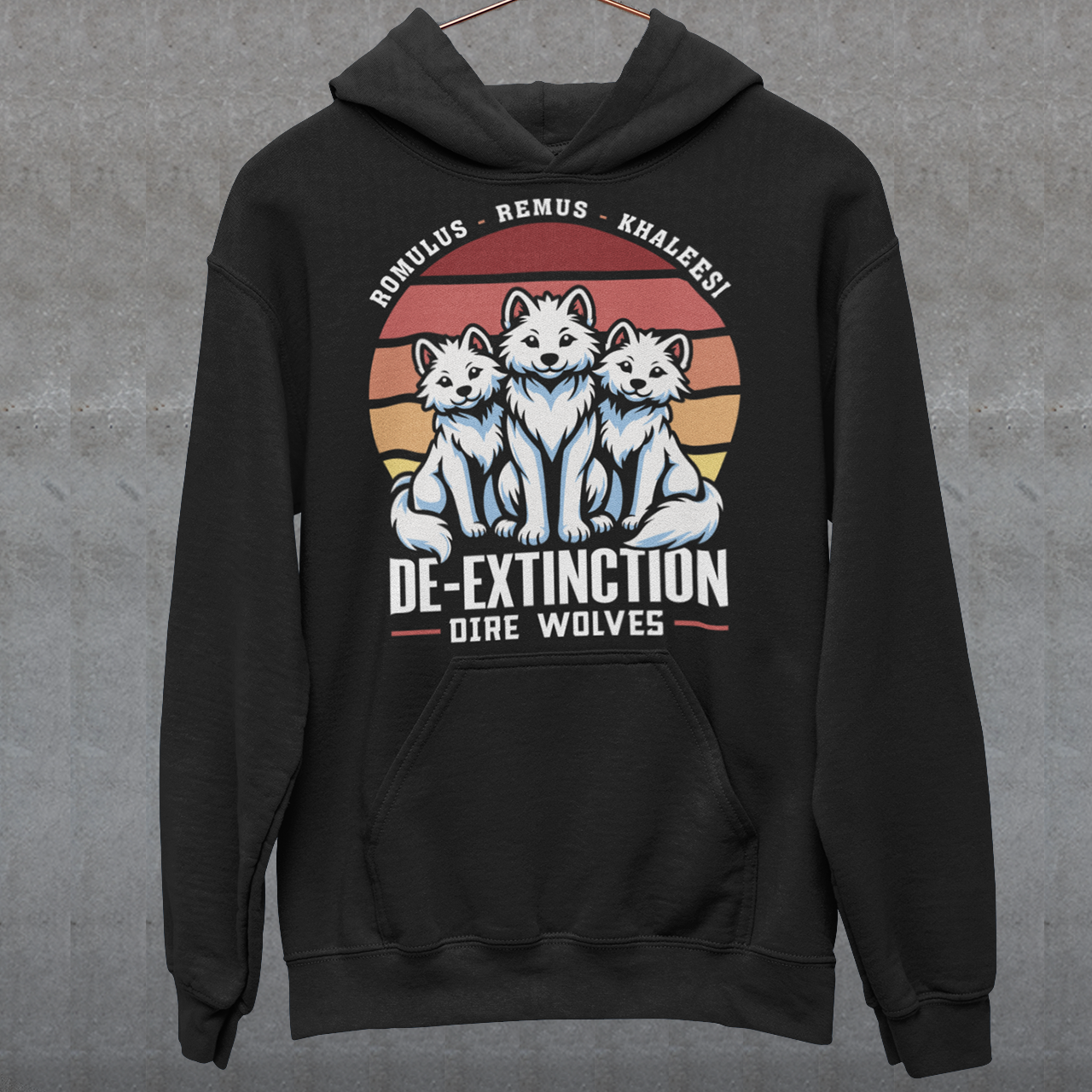 Black hoodie of three Dire Wolves sitting in front of a retro sun with text below DE-EXTINCTION.