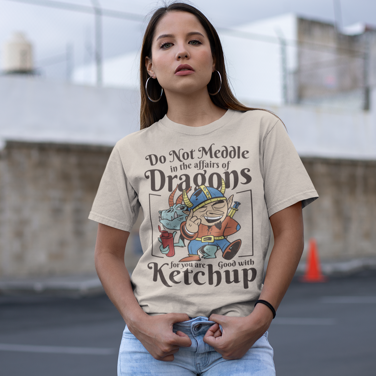 Cream t-shirt of a dragon holding a bottle of ketchup standing behind a viking  with text DO NOT MEDDLE IN THE AFFAIRS OF DRAGONS FOR YOU ARE GOOD WITH KETCHUP.