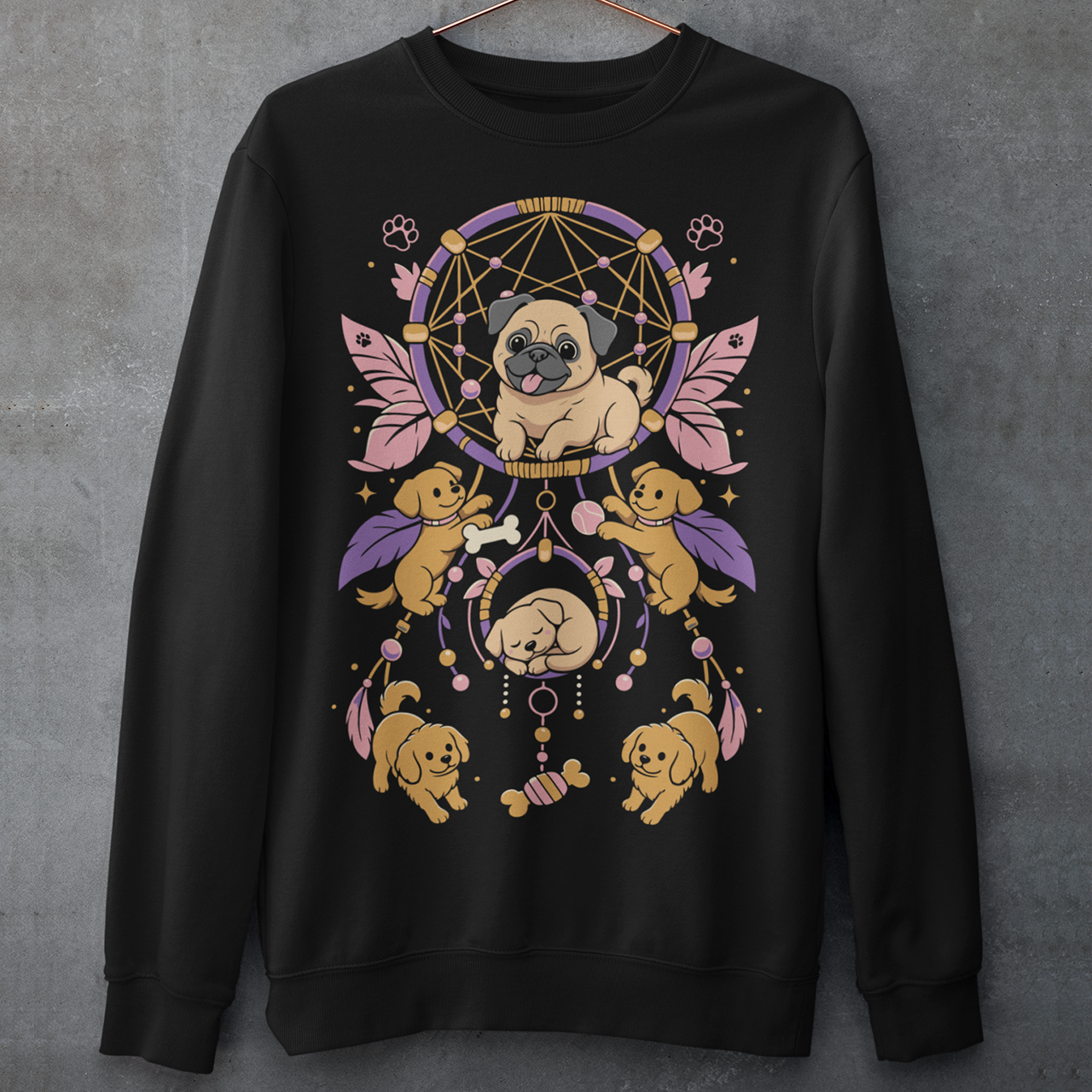 Black sweatshirt featuring a colorful boho dog dreamcatcher design filled with adorable pug puppies. The artwork includes a central pug surrounded by smaller dogs, feathers, beads, paw prints, dog bones, and a sleeping puppy, creating a playful and whimsical pet-themed graphic. Perfect for pug lovers, dog moms, puppy enthusiasts, and fans of cute bohemian dog apparel.