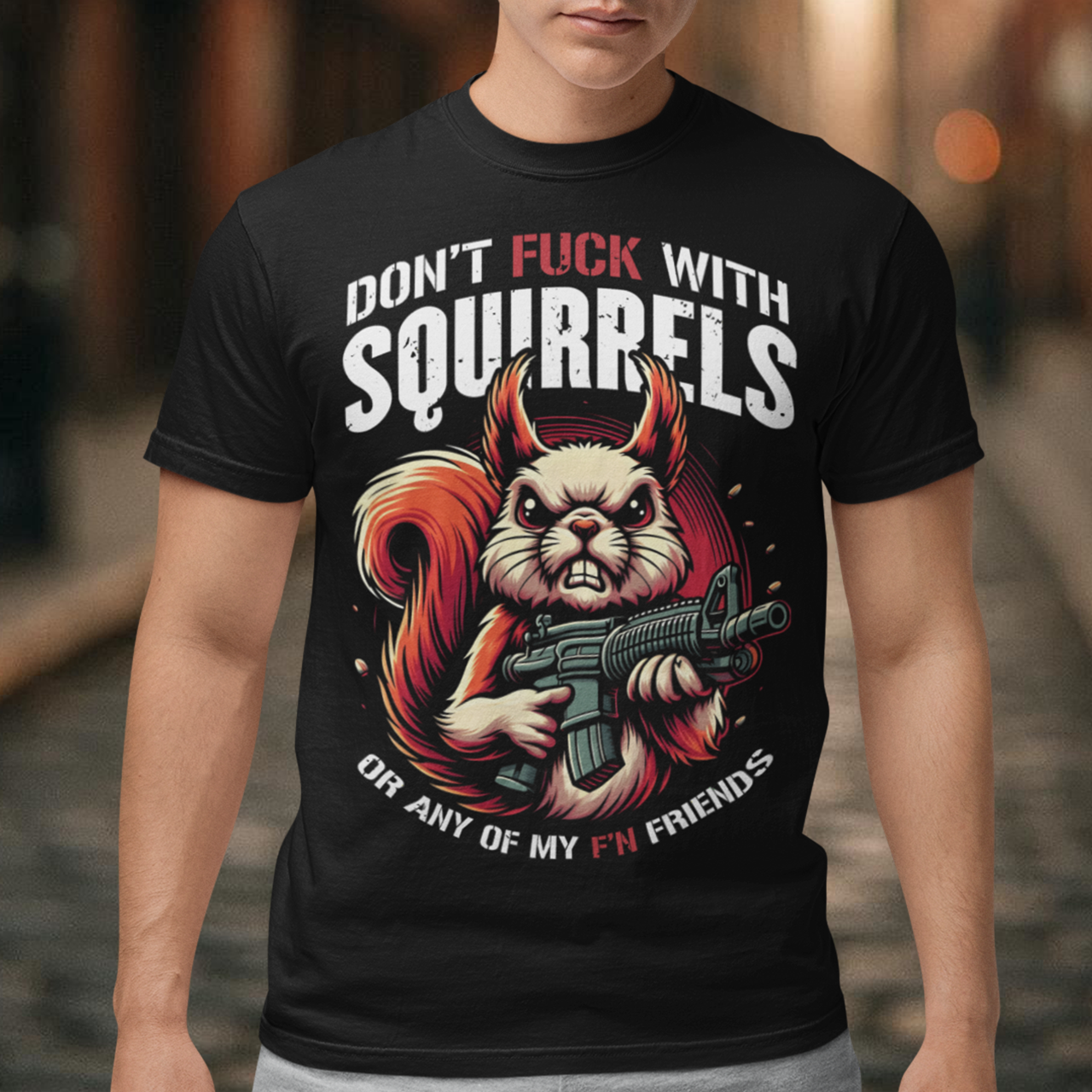 This bold graphic tee features a tough-looking squirrel clutching a pistol, its stance both humorous and a little intimidating. Above the squirrel, in a rugged, distressed font, are the words "DON'T F*CK WITH SQUIRRELS", adding to the edgy vibe of the shirt. Below, the line "OR ANY OF MY F'N FRIENDS" drives the point home, giving the whole design a quirky, rebellious energy. Perfect for animal lovers with a sense of humor or anyone who appreciates a bit of wit and attitude in their wardrobe!