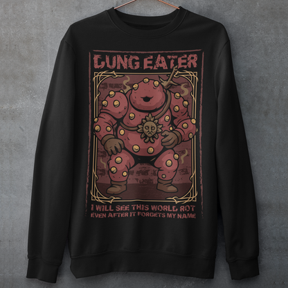 This black sweatshirt features a grim, illustrated tribute to one of dark fantasy’s most unsettling figures Dung Eater. The hulking, corrupted character dominates the design, rendered in deep crimson tones with weathered textures and ornate framing that echo cursed tomes and forgotten prophecies. The bold title above and the chilling line below give the artwork the feeling of a forbidden page torn from a doomed legend.