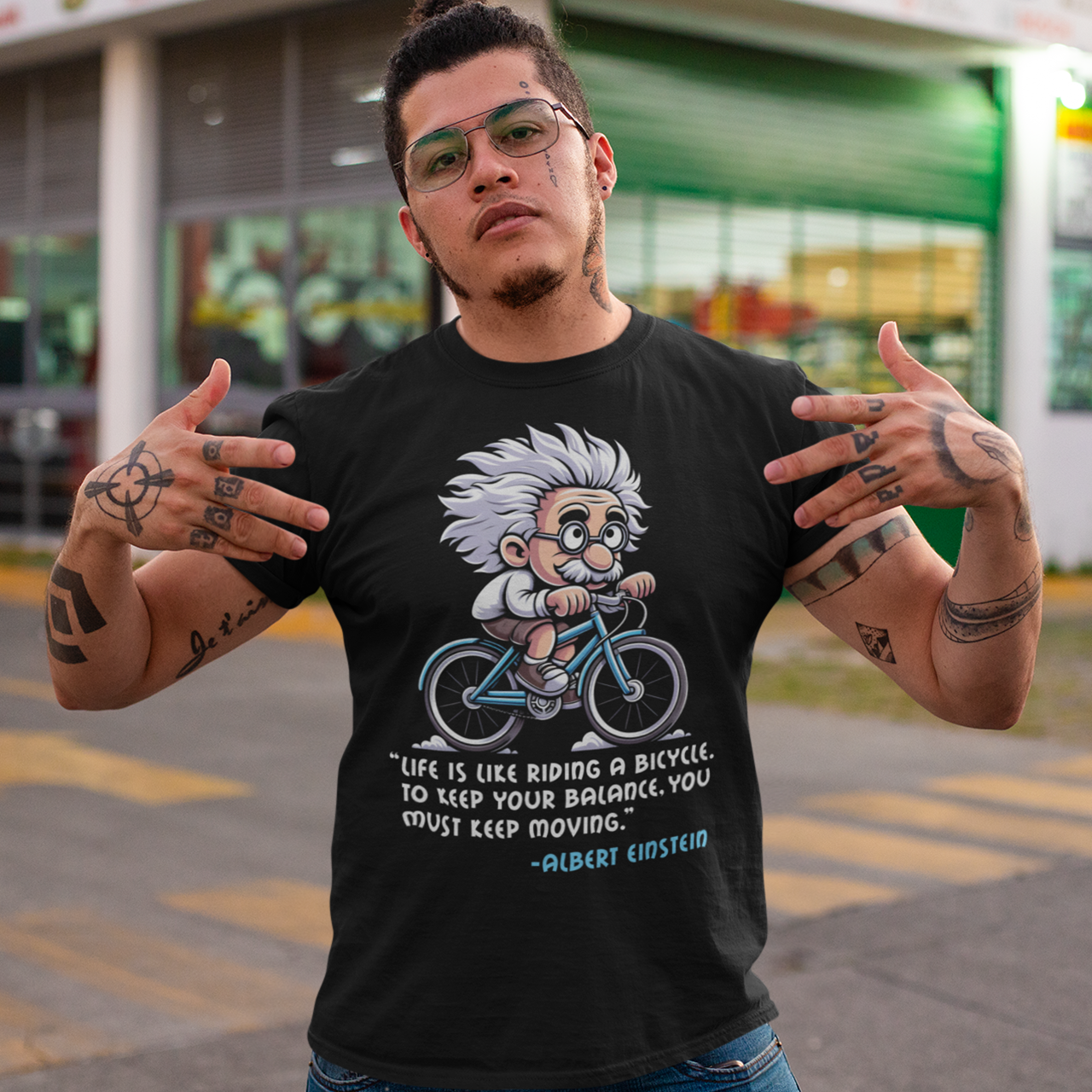 Black t-shirt of Albert Einstein cycling a bike with motivational quote.