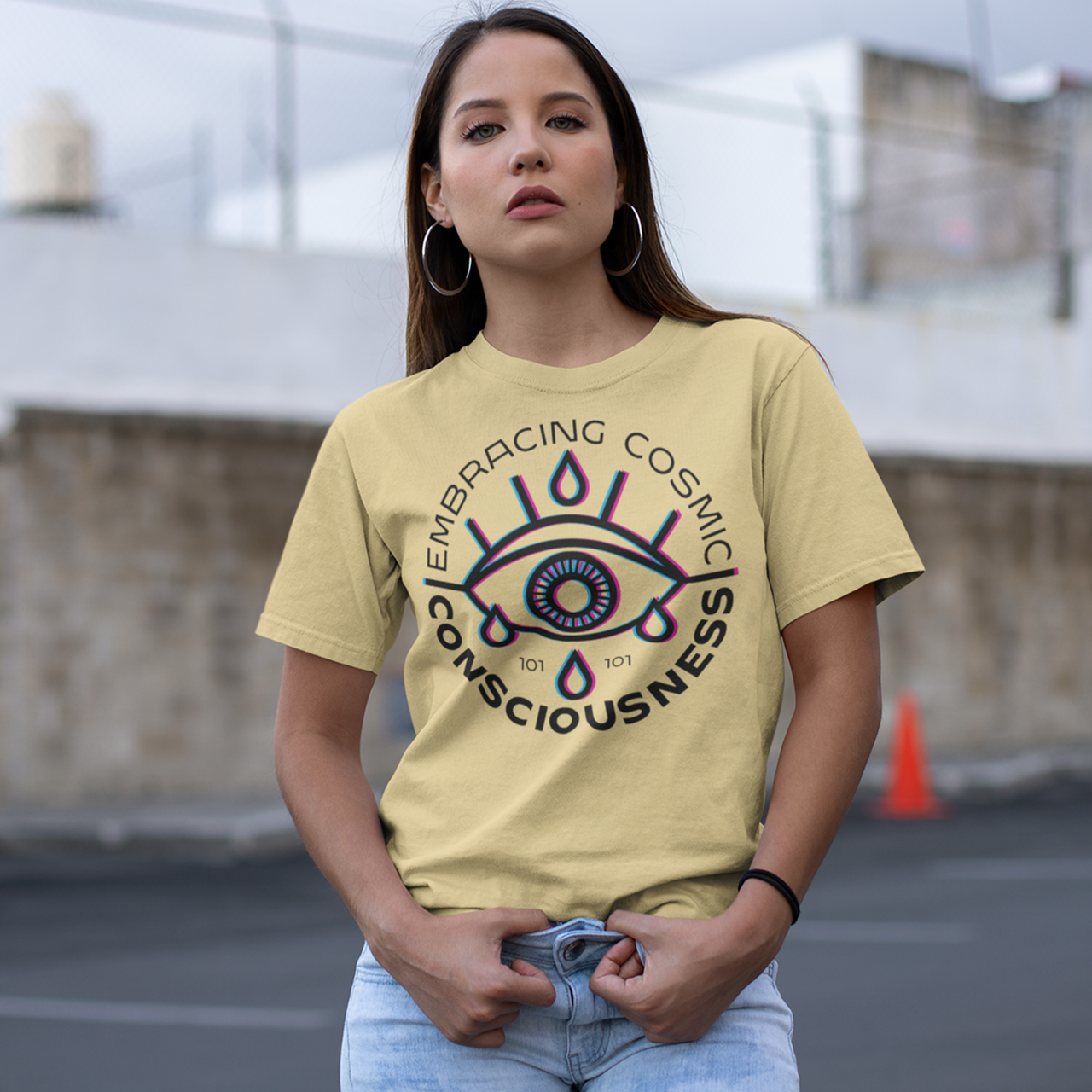 Yellow t-shirt of a glitched eye with text around "EMBRACING COSMIC CONSCIOUSNESS".