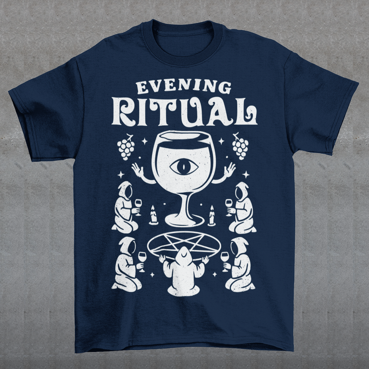 Navy t-shirt featuring a white occult-style graphic with the text “Evening Ritual.” Design shows hooded figures gathered around a pentagram performing a ritual with wine glasses, candles, grapes, and a large mystical wine goblet with an eye symbol. Spooky gothic and illuminati-inspired humor combined with wine lover aesthetics.