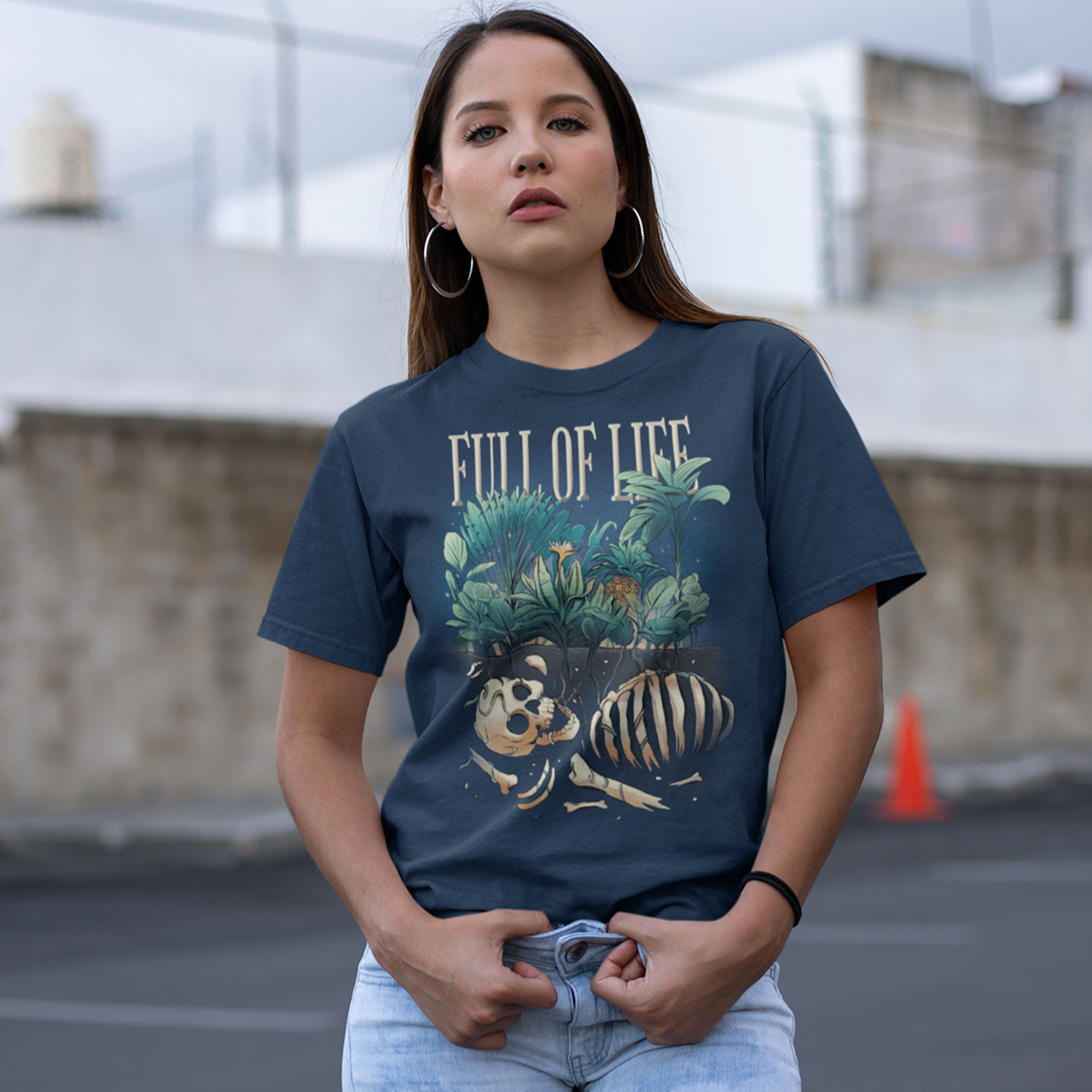 Navy t-shirt of a skeleton buried in the ground with plants growning up from the ground with text "FULL OF LIFE".