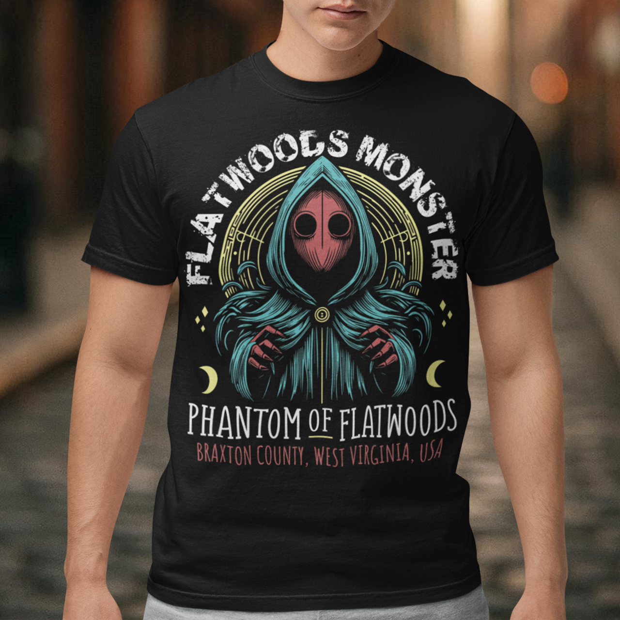 Introducing our Flatwoods Monster tee, where eerie meets style! Above the iconic image of the cryptid, bold white letters spell out "FLATWOODS MONSTER," while below, in a spooky font, "PHANTOM OF FLATWOODS" sets the mood. This t-shirt is perfect for enthusiasts of the paranormal, UFO aficionados, or anyone with an eye for the enigmatic. Flaunt your fascination with the unknown and spark conversations wherever you go.