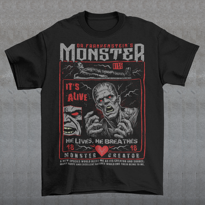 Black horror-themed t-shirt featuring a vintage Frankenstein monster graphic in distressed gray print. The design includes comic-style panels with lightning bolts, Dr. Frankenstein’s monster rising from a lab table, and bold text reading “It’s Alive.” Gothic typography and retro horror artwork give the shirt a classic monster movie aesthetic, perfect for Halloween, horror fans, gothic fashion lovers, and collectors of vintage spooky apparel.