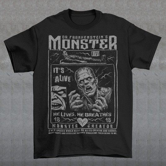 Black horror-themed t-shirt featuring a vintage Frankenstein monster graphic in distressed gray print. The design includes comic-style panels with lightning bolts, Dr. Frankenstein’s monster rising from a lab table, and bold text reading “It’s Alive.” Gothic typography and retro horror artwork give the shirt a classic monster movie aesthetic, perfect for Halloween, horror fans, gothic fashion lovers, and collectors of vintage spooky apparel.