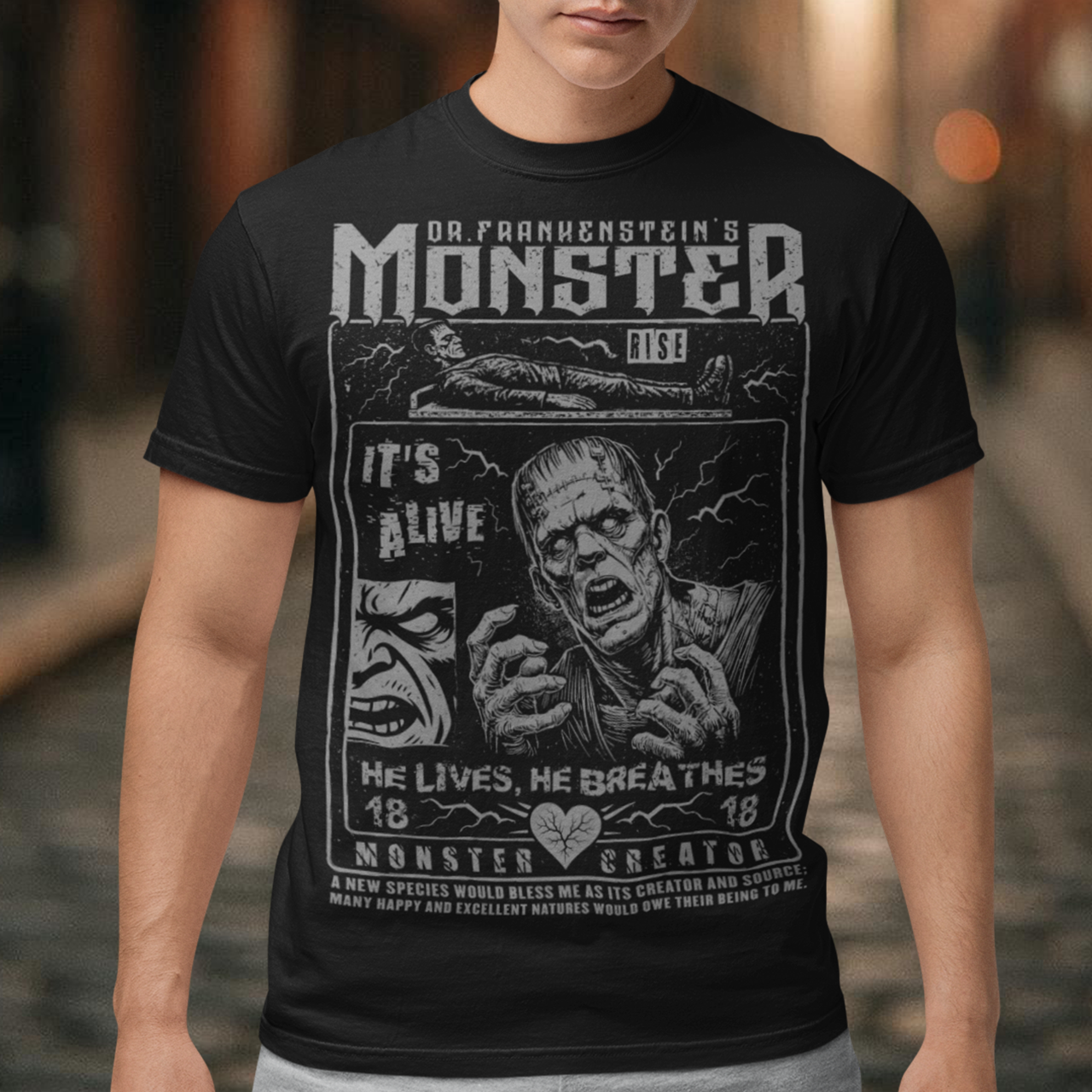 Black horror-themed t-shirt featuring a vintage Frankenstein monster graphic in distressed gray print. The design includes comic-style panels with lightning bolts, Dr. Frankenstein’s monster rising from a lab table, and bold text reading “It’s Alive.” Gothic typography and retro horror artwork give the shirt a classic monster movie aesthetic, perfect for Halloween, horror fans, gothic fashion lovers, and collectors of vintage spooky apparel.