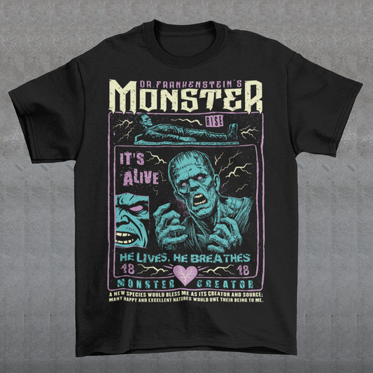 Black horror-themed t-shirt featuring a vintage Frankenstein monster graphic in distressed gray print. The design includes comic-style panels with lightning bolts, Dr. Frankenstein’s monster rising from a lab table, and bold text reading “It’s Alive.” Gothic typography and retro horror artwork give the shirt a classic monster movie aesthetic, perfect for Halloween, horror fans, gothic fashion lovers, and collectors of vintage spooky apparel.