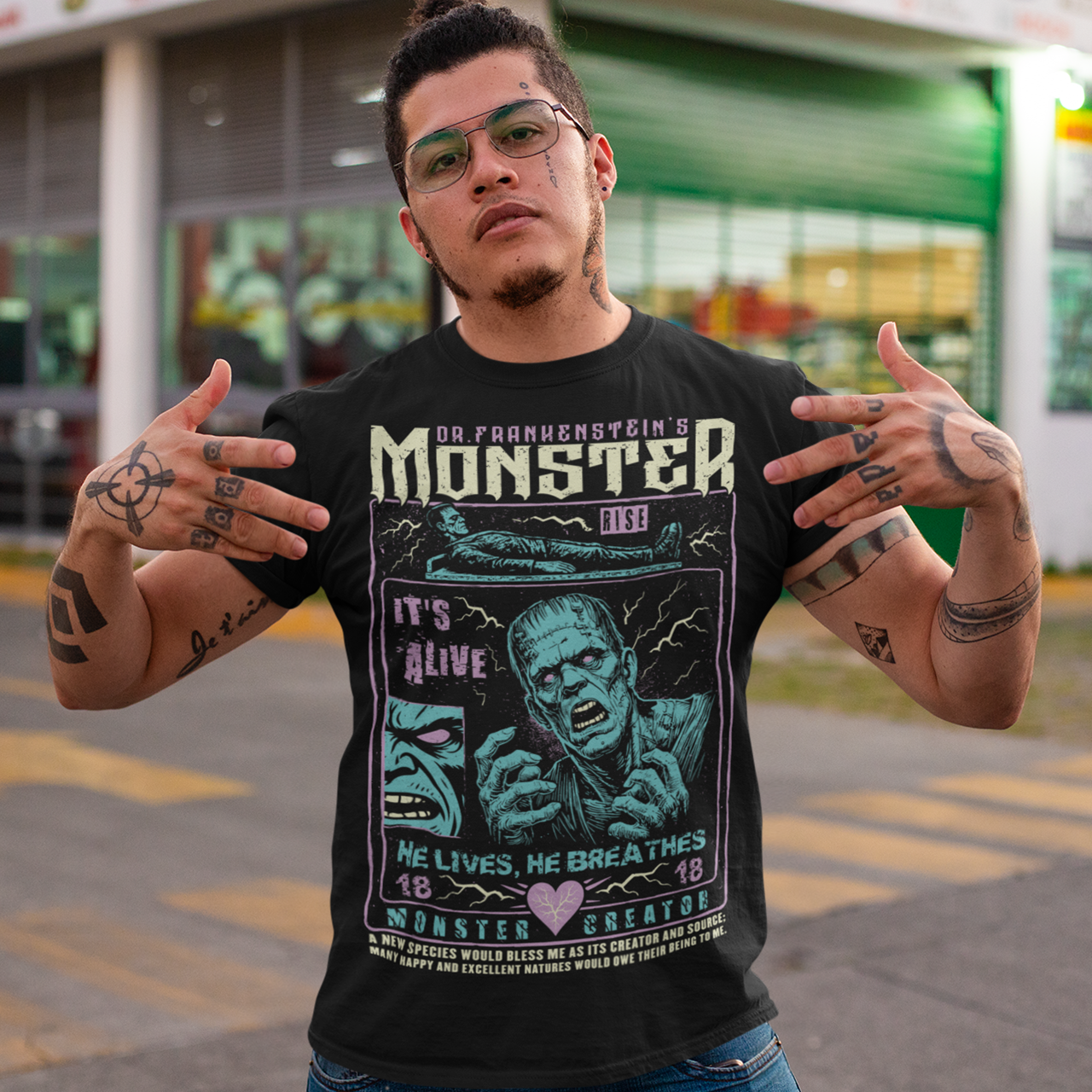 Black horror-themed t-shirt featuring a vintage Frankenstein monster graphic in distressed gray print. The design includes comic-style panels with lightning bolts, Dr. Frankenstein’s monster rising from a lab table, and bold text reading “It’s Alive.” Gothic typography and retro horror artwork give the shirt a classic monster movie aesthetic, perfect for Halloween, horror fans, gothic fashion lovers, and collectors of vintage spooky apparel.