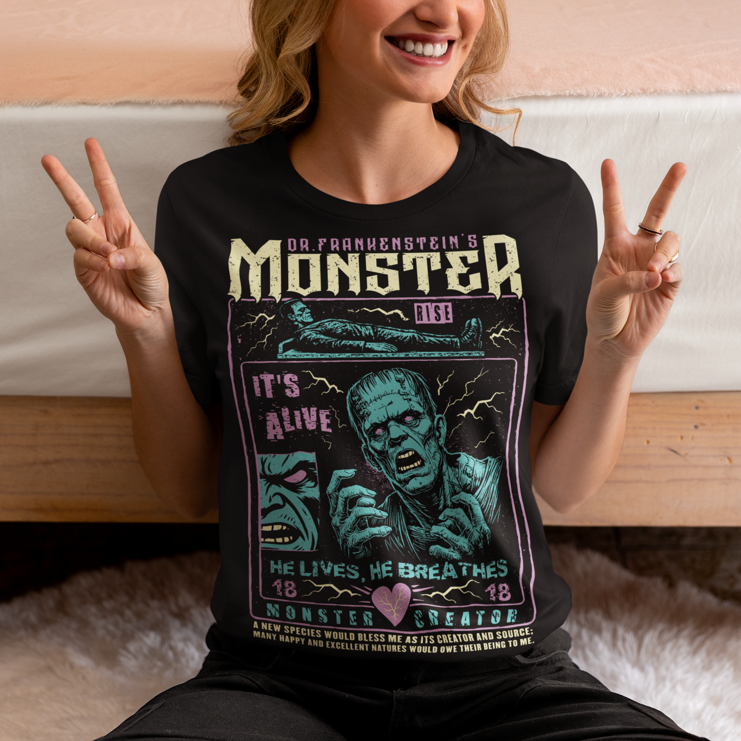 Black horror-themed t-shirt featuring a vintage Frankenstein monster graphic in distressed gray print. The design includes comic-style panels with lightning bolts, Dr. Frankenstein’s monster rising from a lab table, and bold text reading “It’s Alive.” Gothic typography and retro horror artwork give the shirt a classic monster movie aesthetic, perfect for Halloween, horror fans, gothic fashion lovers, and collectors of vintage spooky apparel.
