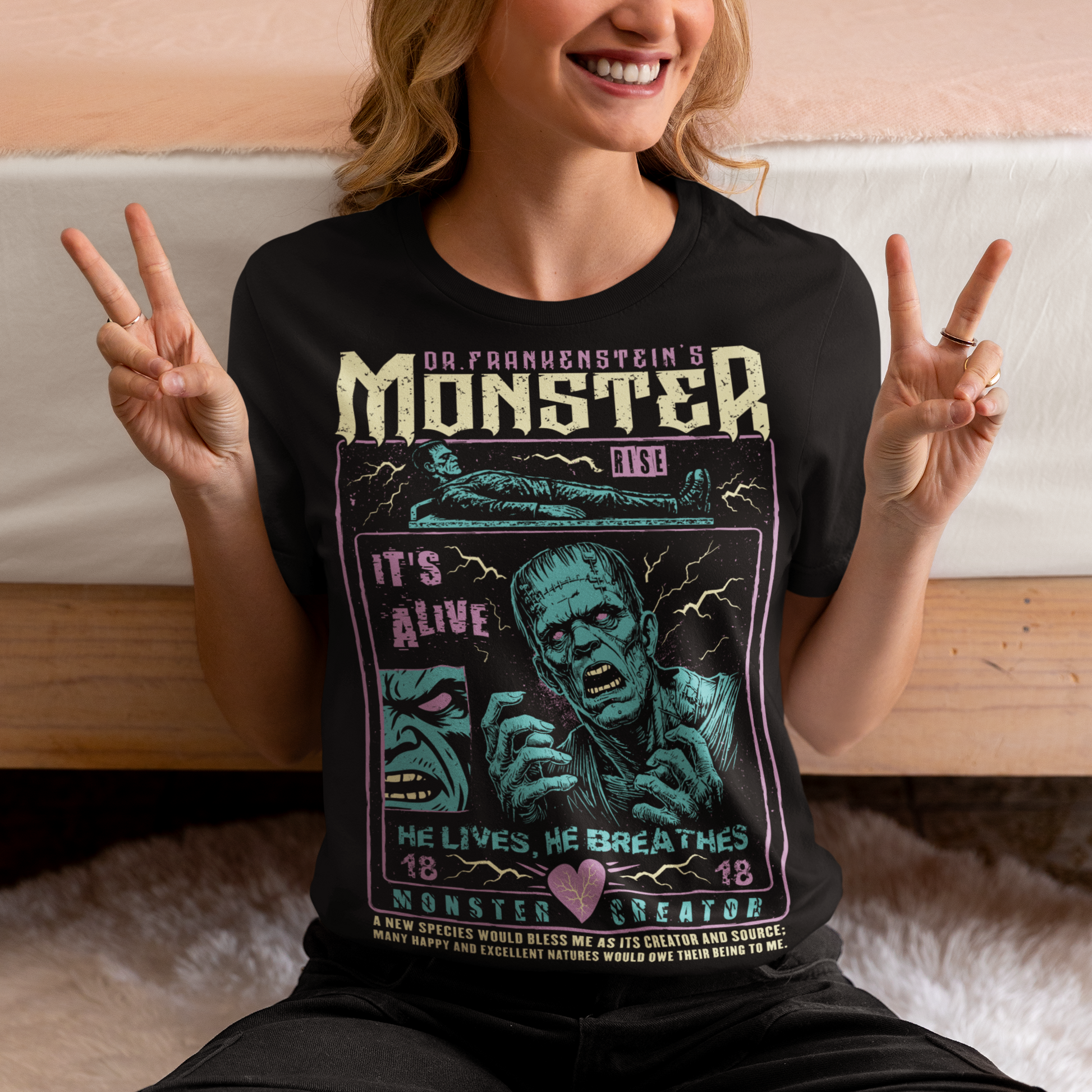 Black horror-themed t-shirt featuring a vintage Frankenstein monster graphic in distressed gray print. The design includes comic-style panels with lightning bolts, Dr. Frankenstein’s monster rising from a lab table, and bold text reading “It’s Alive.” Gothic typography and retro horror artwork give the shirt a classic monster movie aesthetic, perfect for Halloween, horror fans, gothic fashion lovers, and collectors of vintage spooky apparel.