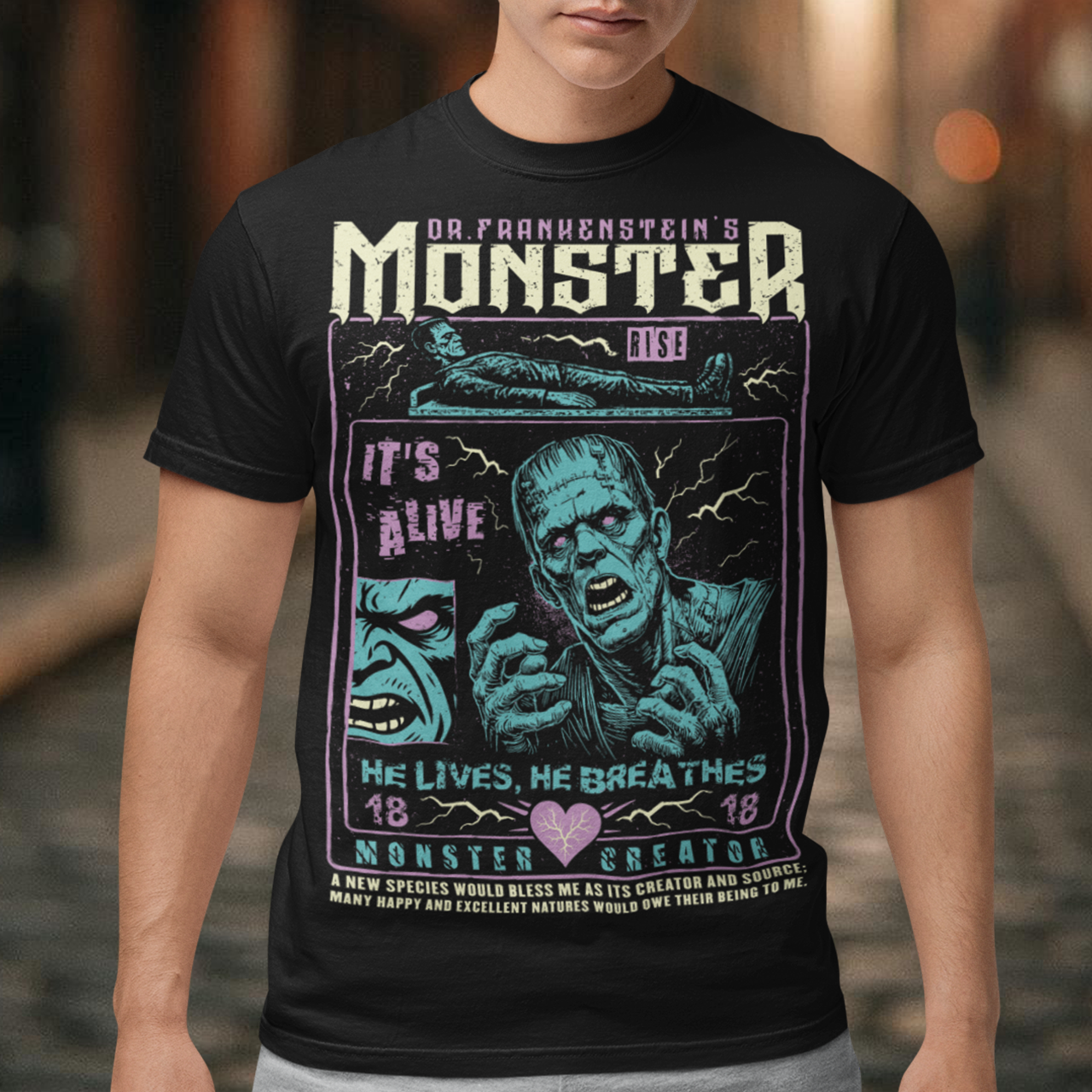 Black horror-themed t-shirt featuring a vintage Frankenstein monster graphic in distressed gray print. The design includes comic-style panels with lightning bolts, Dr. Frankenstein’s monster rising from a lab table, and bold text reading “It’s Alive.” Gothic typography and retro horror artwork give the shirt a classic monster movie aesthetic, perfect for Halloween, horror fans, gothic fashion lovers, and collectors of vintage spooky apparel.