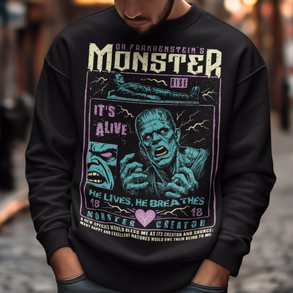 Black horror-themed sweatshirt featuring a vintage Frankenstein monster graphic in distressed gray print. The design includes comic-style panels with lightning bolts, Dr. Frankenstein’s monster rising from a lab table, and bold text reading “It’s Alive.” Gothic typography and retro horror artwork give the shirt a classic monster movie aesthetic, perfect for Halloween, horror fans, gothic fashion lovers, and collectors of vintage spooky apparel.