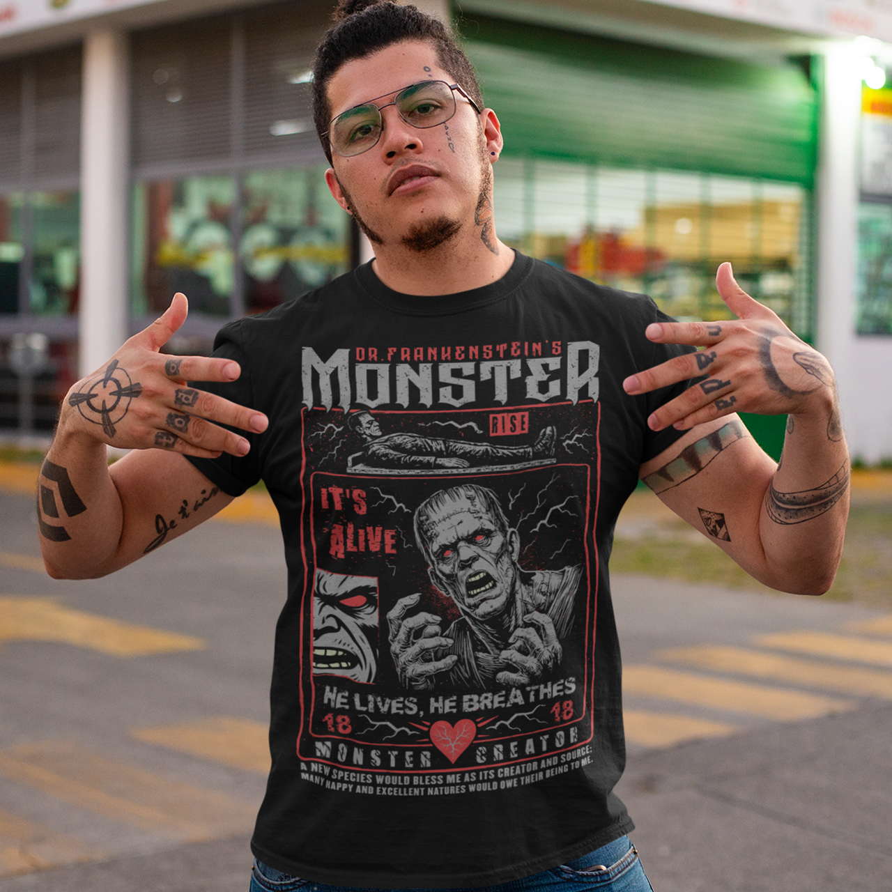 Black horror-themed t-shirt featuring a vintage Frankenstein monster graphic in distressed gray print. The design includes comic-style panels with lightning bolts, Dr. Frankenstein’s monster rising from a lab table, and bold text reading “It’s Alive.” Gothic typography and retro horror artwork give the shirt a classic monster movie aesthetic, perfect for Halloween, horror fans, gothic fashion lovers, and collectors of vintage spooky apparel.